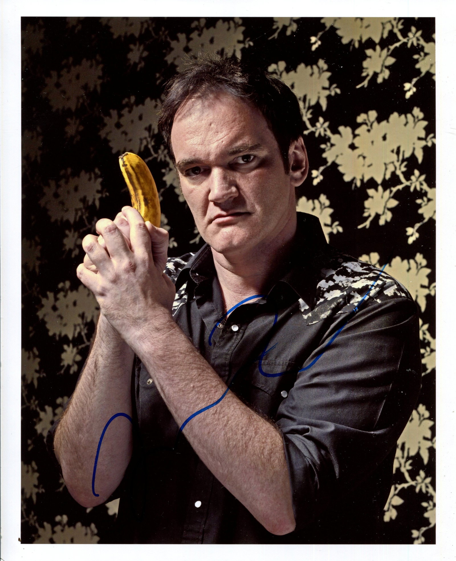 TARANTINO QUENTIN: (1963- ): TARANTINO QUENTIN: (1963- ) American film director, Academy Award winner. Signed colour 8 x 10 photograph of Tarantino in a half-length pose, tightly gripping a banana in his hands, in a nod of