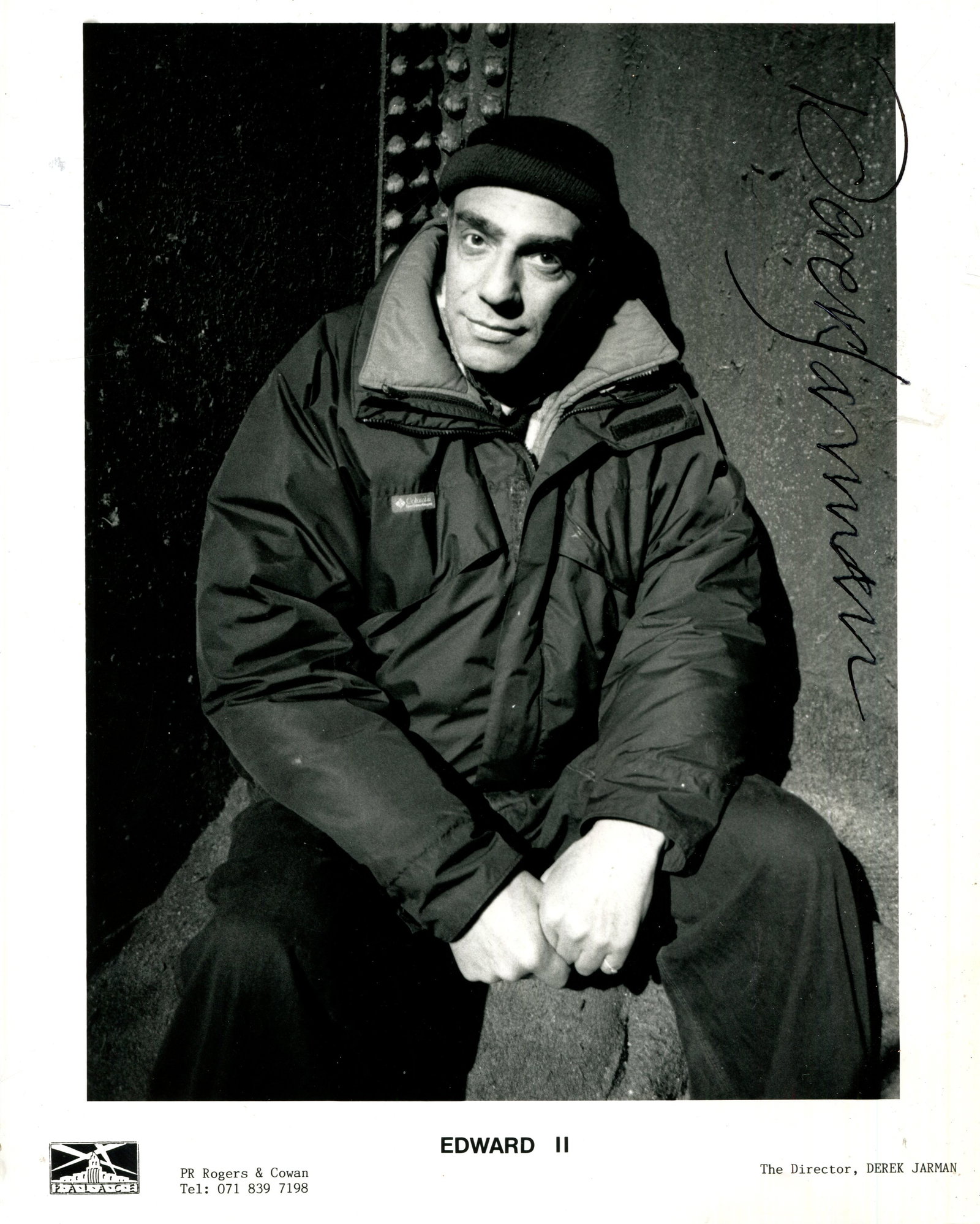 JARMAN DEREK: (1942-1994): JARMAN DEREK: (1942-1994) English film director, artist and gay rights activist. A scarce signed 8 x 10 photograph of Jarman seated in a three-quarter length pose on the set of his British romantic