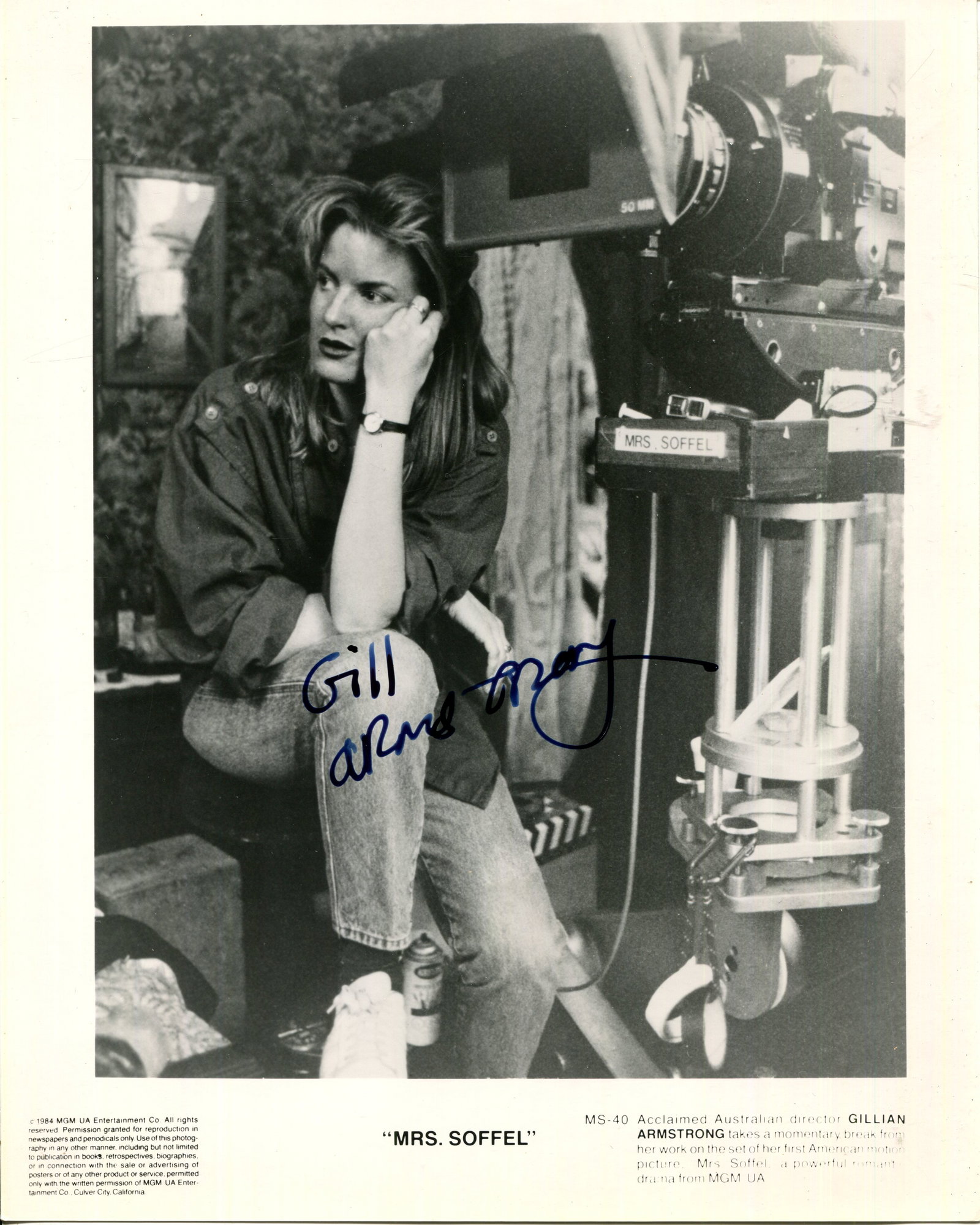 ARMSTRONG GILLIAN: (1950- ): ARMSTRONG GILLIAN: (1950- ) Australian film director. Signed 8 x 10 photograph of Armstrong seated in a full-length pose alongside a large camera on the set of her drama film Mrs. Soffel (1984).