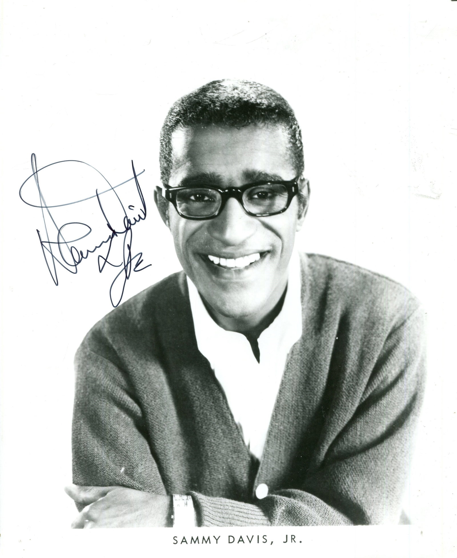 DAVIS JR. SAMMY: (1925-1990): DAVIS JR. SAMMY: (1925-1990) American entertainer, a member of the Rat Pack. Signed 8 x 10 photograph of Davis Jr. in a smiling head and shoulders pose. Signed in black ink with his name alone to a