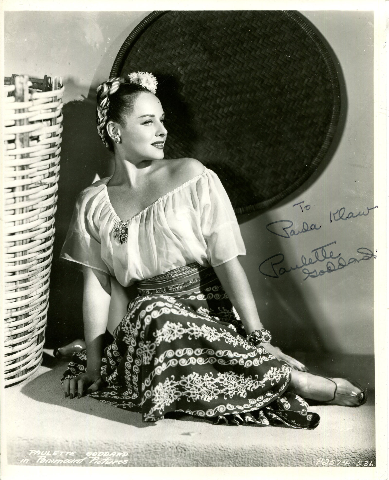 GODDARD PAULETTE: (1910-1990): GODDARD PAULETTE: (1910-1990) American actress. Signed and inscribed 8 x 10 photograph of Goddard seated in an appealing full-length pose with flowers in her hair. Signed in black ink across a