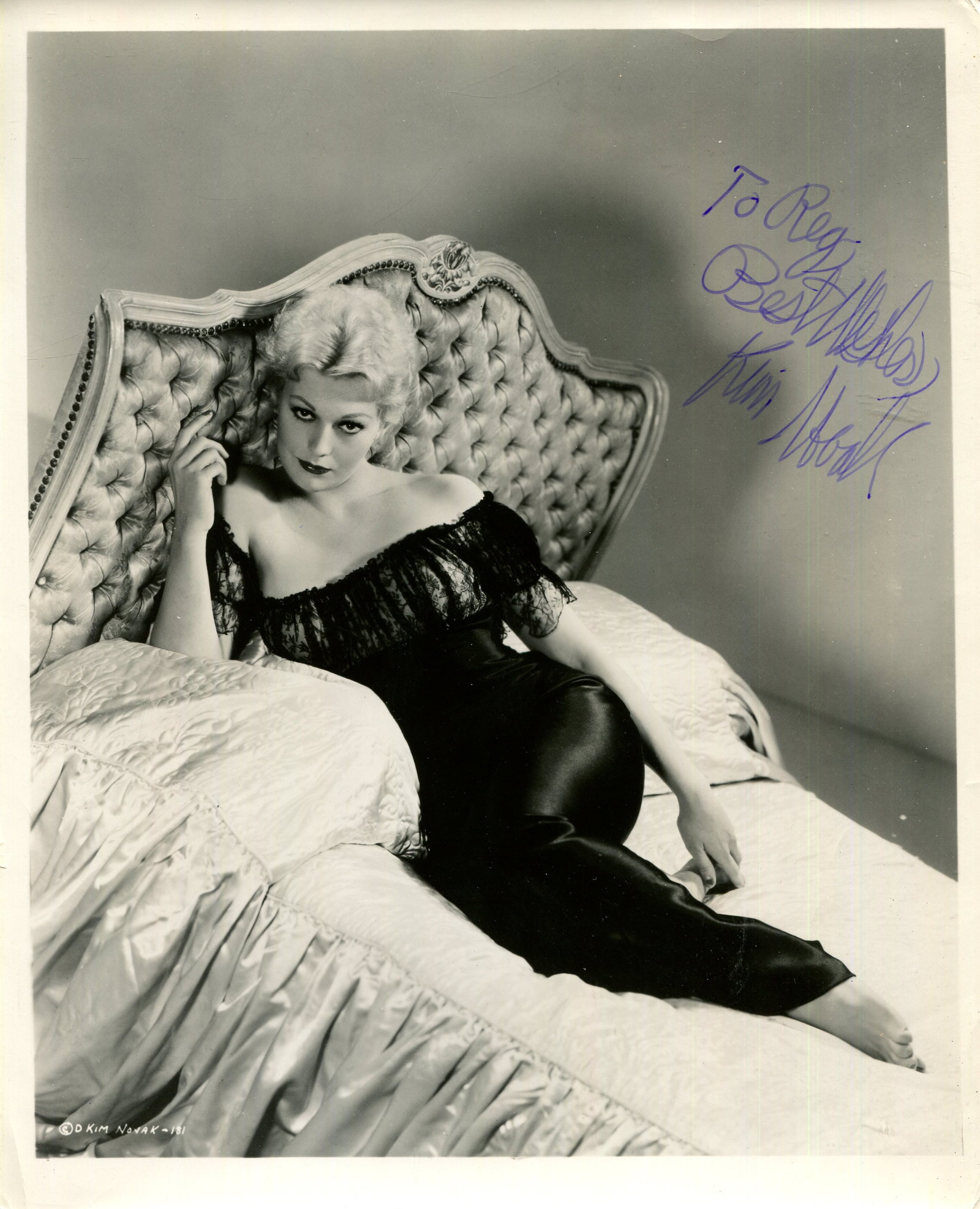 NOVAK KIM: (1933- ): NOVAK KIM: (1933- ) American actress. A good vintage signed and inscribed 8 x 10 photograph of the blonde actress lying in a seductive full-length pose on a bed, the original Columbia Pictures