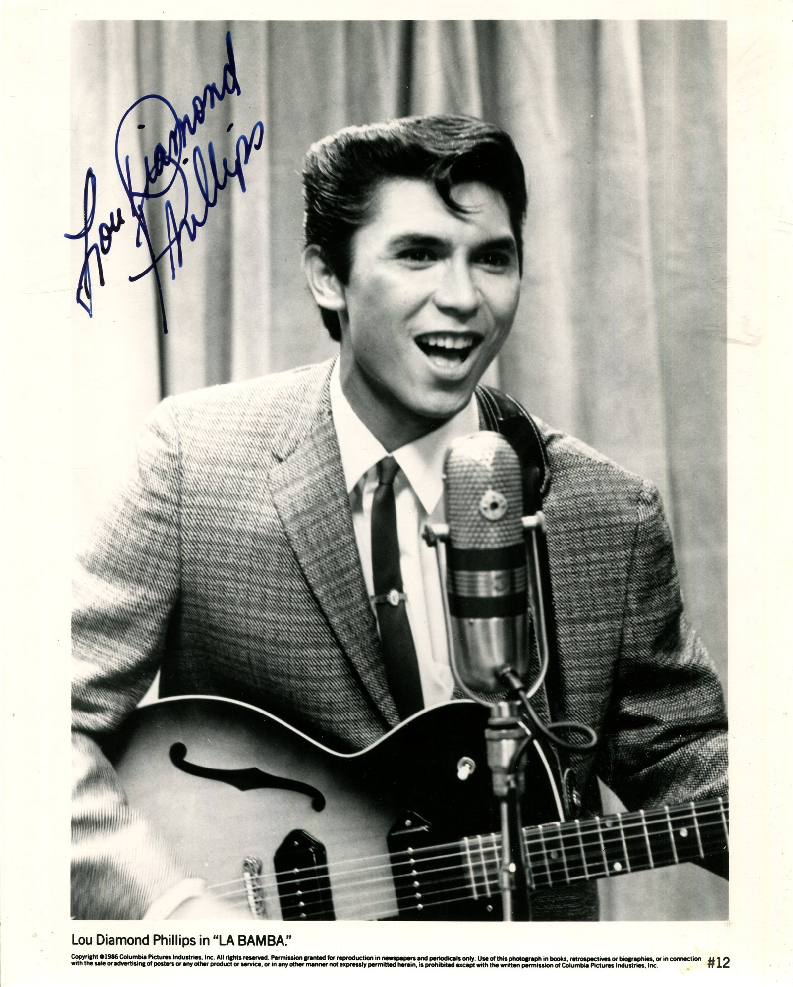 PHILLIPS LOU DIAMOND: (1962- ): PHILLIPS LOU DIAMOND: (1962- ) American actor. Signed 8 x 10 photograph of Phillips standing in a half-length pose in costume from his breakthrough role as rock and roll pioneer Ritchie Valens,