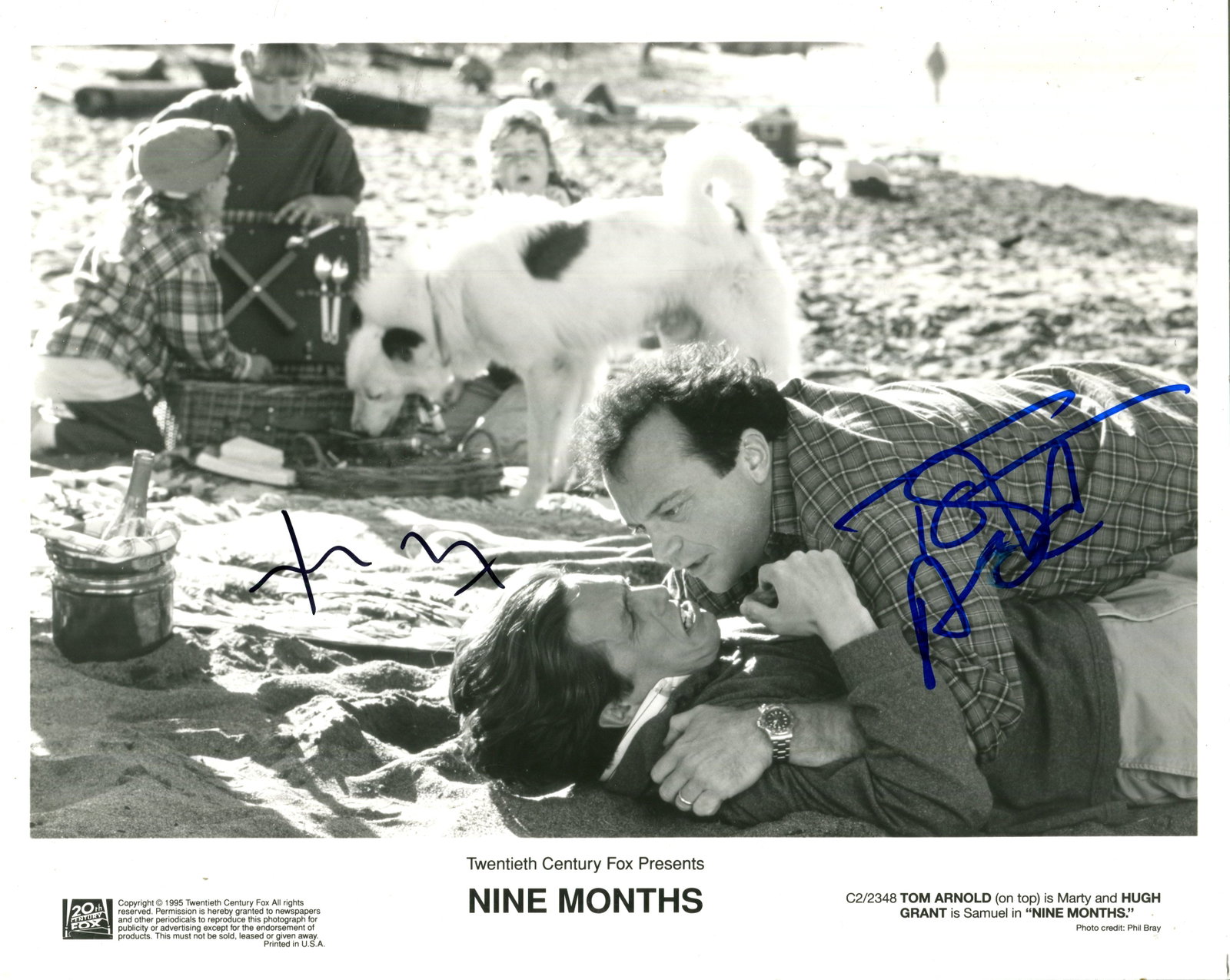 NINE MONTHS: NINE MONTHS: Signed 10 x 8 photograph by Tom Arnold (1959- ) and Hugh Grant (1960- ). The promotional image depicting both actors outdoors in half-length poses, Arnold in costume as Marty on top of
