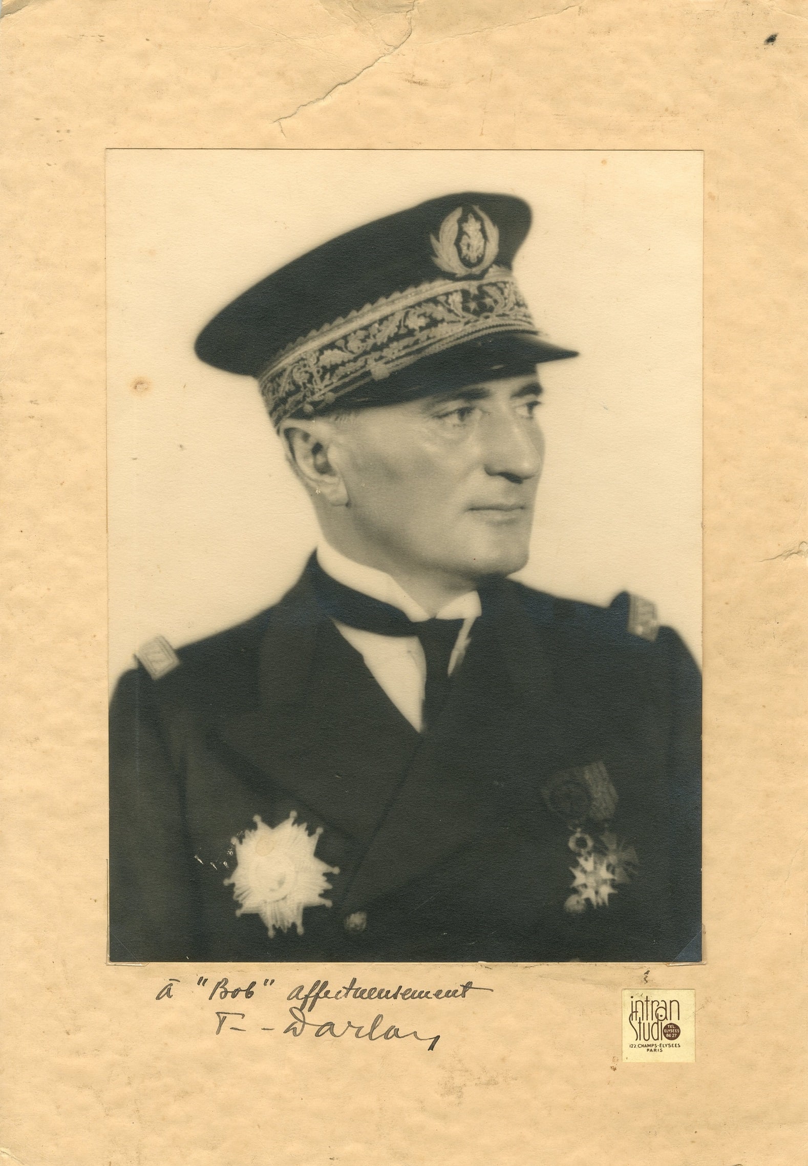 DARLAN FRAN?OIS: (1881-1942): DARLAN FRANÇOIS: (1881-1942) French Admiral of World War II. Vintage signed and inscribed sepia 9 x 13 photograph of the Admiral in a head and shoulders pose wearing his uniform, cap and medals.
