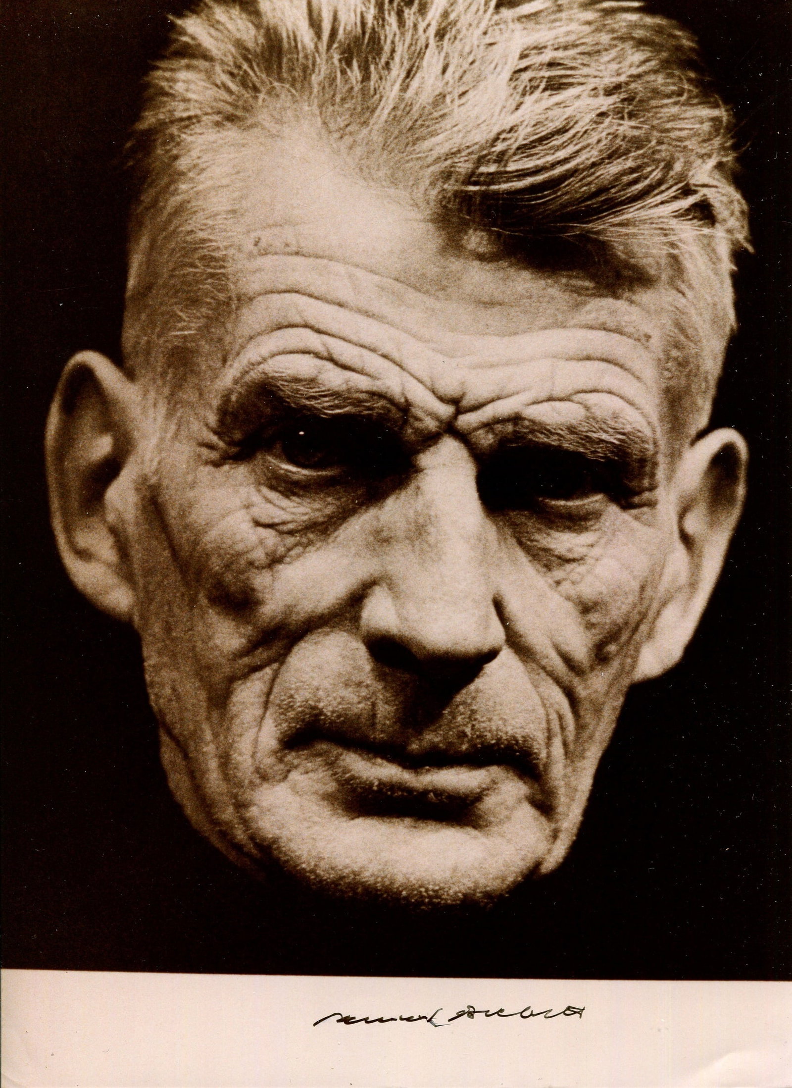 BECKETT SAMUEL: (1906-1989): BECKETT SAMUEL: (1906-1989) Irish novelist & dramatist, Nobel Prize winner for Literature, 1969. Signed 8 x 11 photograph, an engaging close-up portrait of Beckett. Signed in black ink with his name