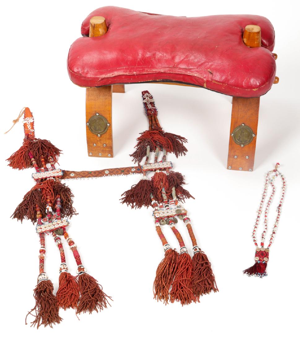 Old North African/Bedouin camel saddle or stool: Old North African/Bedouin camel saddle/stool with tasseled and embroidered animal trapping with Ottoman coins attached. Ranging in size from 17.5" (44 cm) in length to 15'' x 24'' x 14'' (38 x 61 x 36