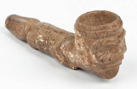 Taino Pipe (1000-1500 CE): Taino Pipe (1000-1500 CE). Bowl depicts human face, stem is a full figured reptilian form. Brownish hard stone with white inclusions. Provenance: Larry Roberts, author of Taino Sculpture: Art of the