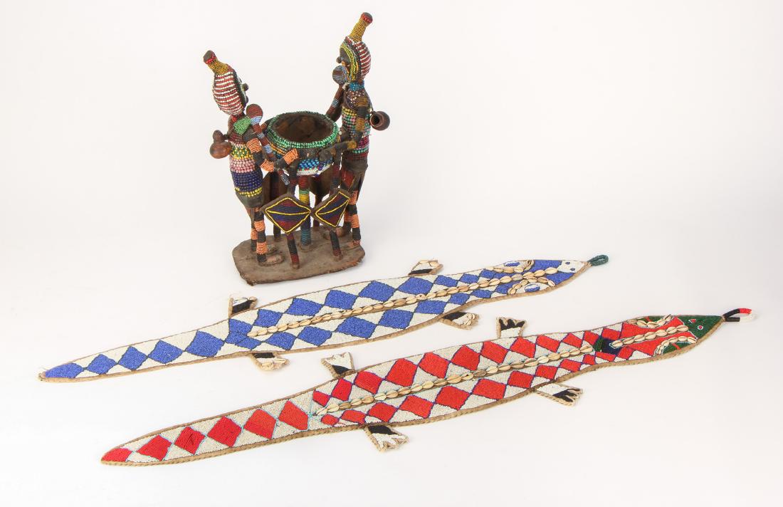 Three African Yoruba Beaded Objects, Nigeria: Three African Yoruba Beaded Objects. Including a figural beaded cola nut container and two beaded and cowrie shell decorated crocodile wall hangings. Ranging in size from: 43'' x 10'' (109 x 25 cm) to