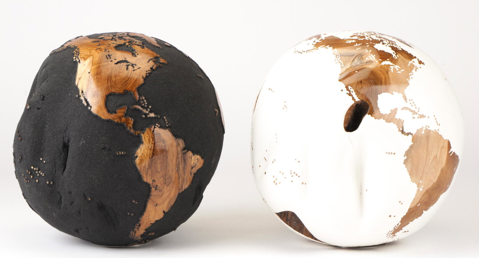 Two Bruno Helgen Globes: Bruno Helgen (French, b. 1959). Two Teak Wood Root Globes. (1) White finish. Metallic monogram. Bottom Stamped: 230/2014. (2) Black volcanic sand. Metallic monogram. Bottom stamped: 434/2014. Each on 
