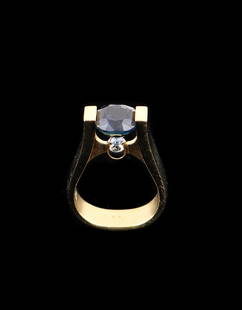 18k Yellow Gold Oval Faceted Sapphire Ring: 18k yellow gold oval faceted sapphire ring, sapphire approximately 3.28 cts., marked 18k and an unidentifiable hallmark. Diameter: .75" (2 cm); Stone Portion: .25'' x .25'' x .25'' (1 x 1 x 1 cm).