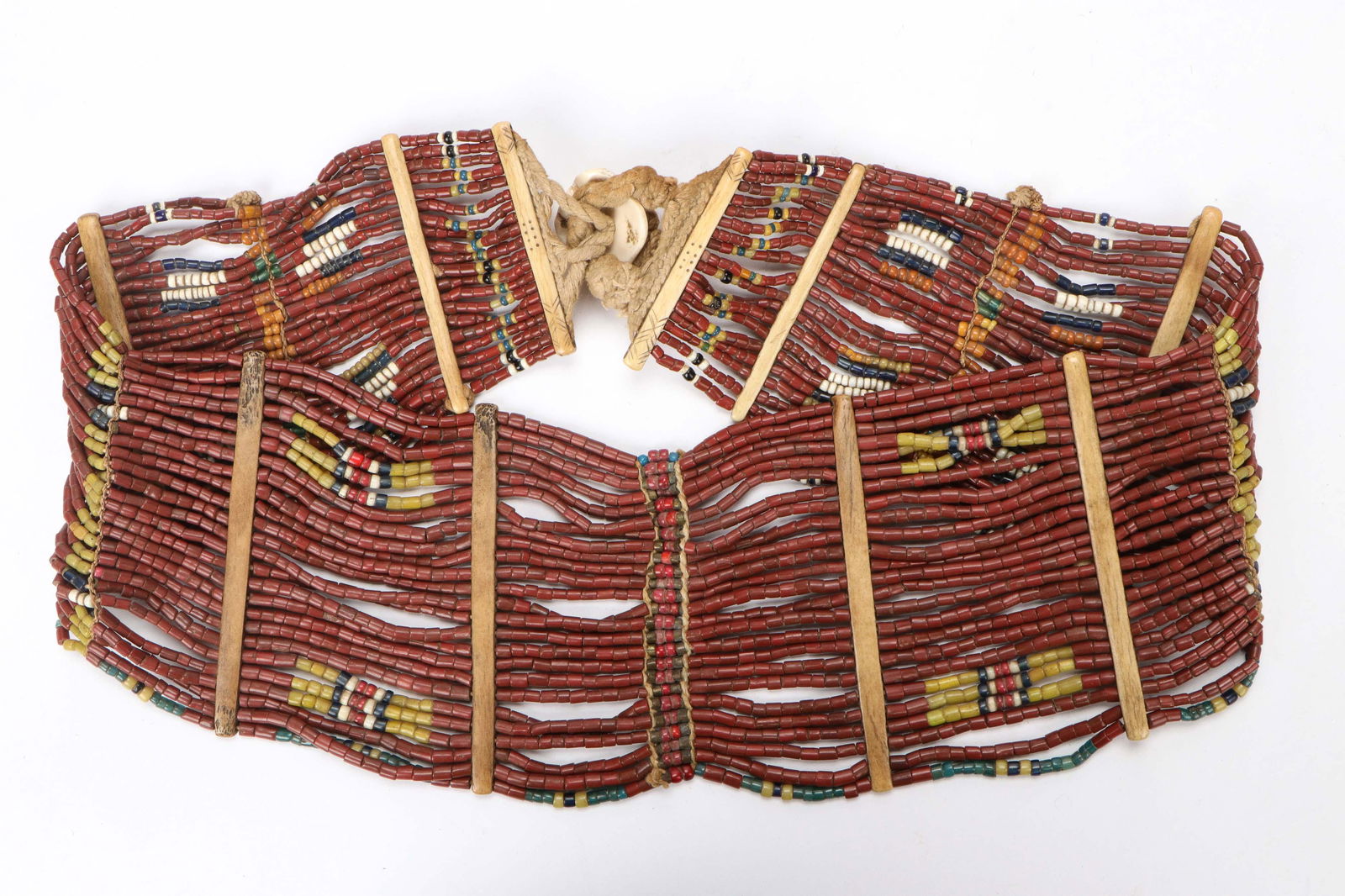 Antique Konyak Naga Brown Belt: Antique Konyak Naga Brown Belt. Brown glass trade beads, with Konyak design incised bone separators at ends and an antique chank shell button. Festival belt worn by young women of high status. Size: 3