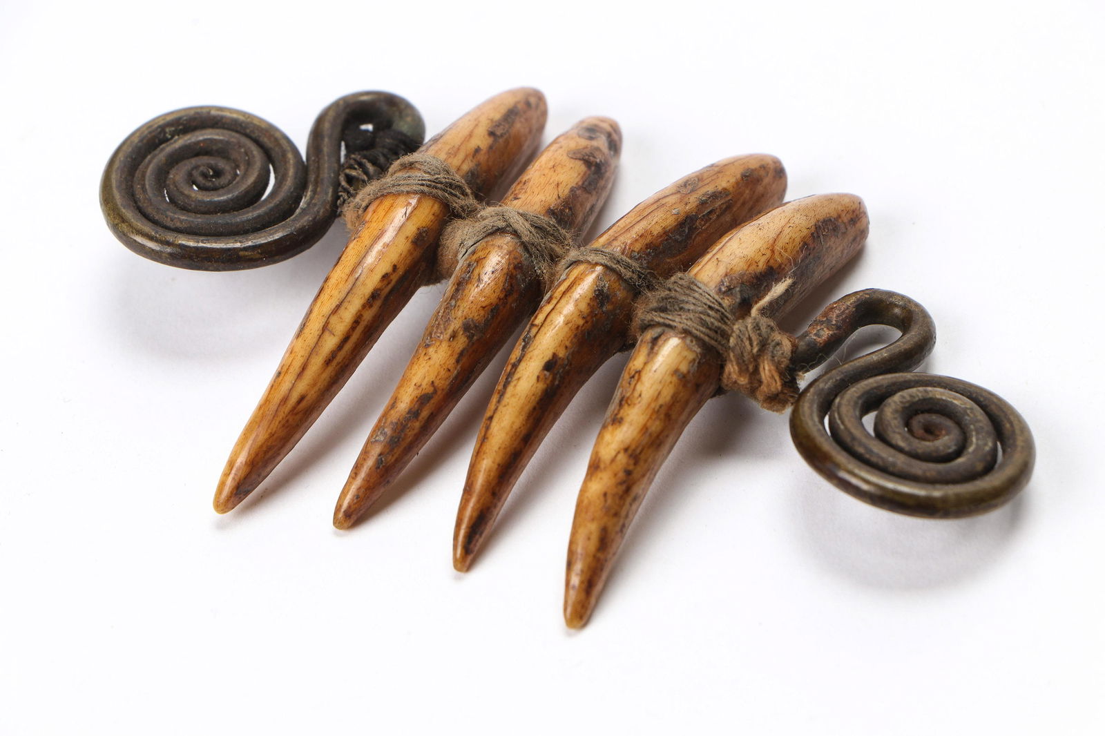 Chang Naga Bone Tiger's Teeth Style Pendant: Chang Naga Bone Tiger's Teeth Style Pendant. Old bone parts in a lower status version of a warrior's more sacred tiger's teeth pendant, with brass spiral findings.Size: 2'' x 4'' x .5'' (5 x 10 x 1 cm