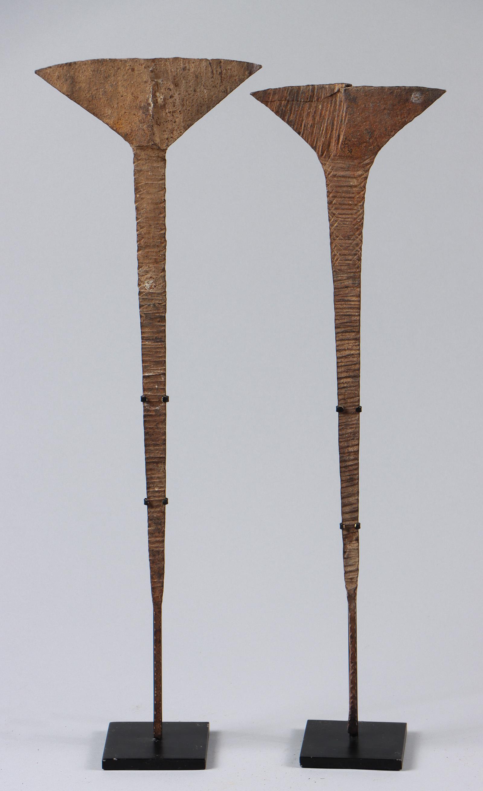 2 African Idoma Metal Hoe Currency, Akika, Nigeria: Two African Idoma Metal Hoe Currency, Akika, Nigeria. On stands. Sizes: 1) 30'' x 9.5'' (76 x 24 cm); Height on Stand: 30.75" (78 cm); 2) 29'' x 8'' (74 x 20 cm); Height on Stand: 30" (76 cm). Ex. Cat
