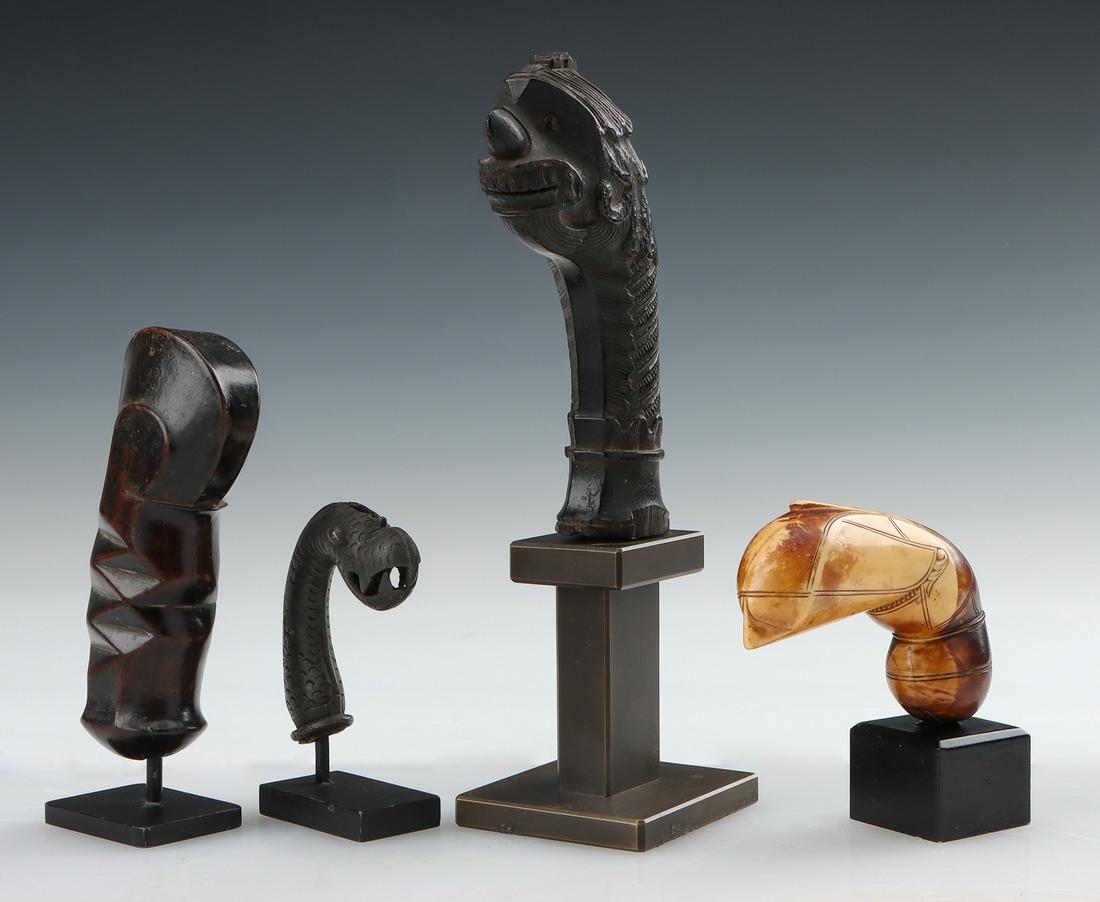 Four Antique Indonesian Kris and Sword Handles: Four Antique Indonesian Kris and Sword Handles. Carved wood and bone. On stands. Ranging in Size from: 3'' x 2.75'' x 1'' (8 x 7 x 3 cm); Height on Stand: 4" (10 cm) to 5.75'' x 3.75'' x 1.5'' (15 x 1