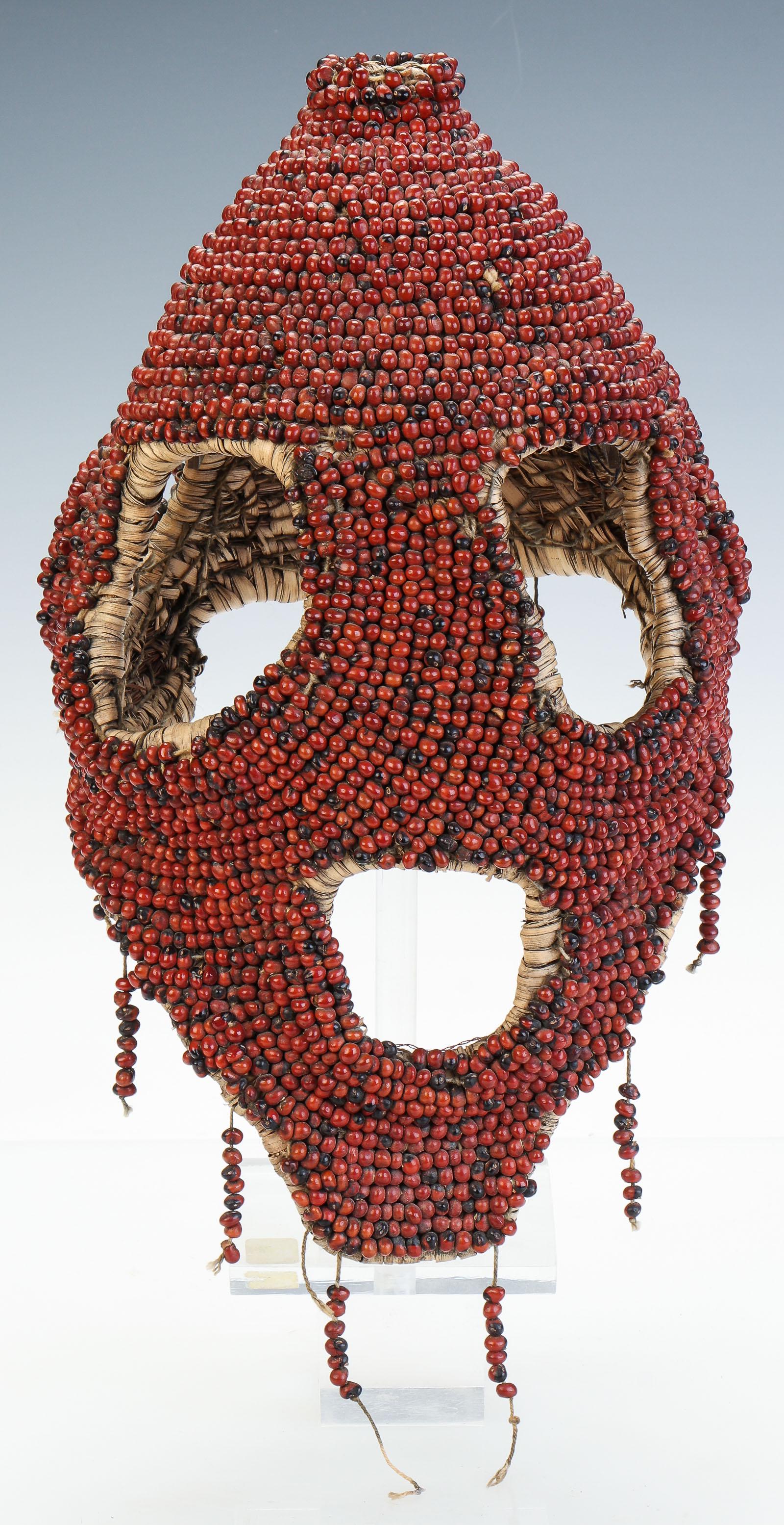 African Koro / Angas Peoples Abrus Seed Mask, Nigeria: African Koro / Angas Peoples Abrus Seed Mask, Nigeria. Woven plant fiber covered with red abrus seeds, with large eyes and mouth, North Nigerian, 20th century. On stand. Size: 15'' x 9'' x 9'' (38 x 2