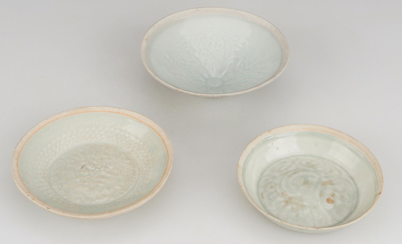 3 Chinese Celadon Glazed Bowls: 3 Chinese Celadon Glazed Bowls. Size: Ranging from: 1.25'' x 5.5'' x 5.5'' (3 x 14 x 14 cm) to 2'' x 6.25'' x 6.25'' (5 x 16 x 16 cm). Provenance: Sylvia and Philip Chaplain Collection, New Hampshire.
