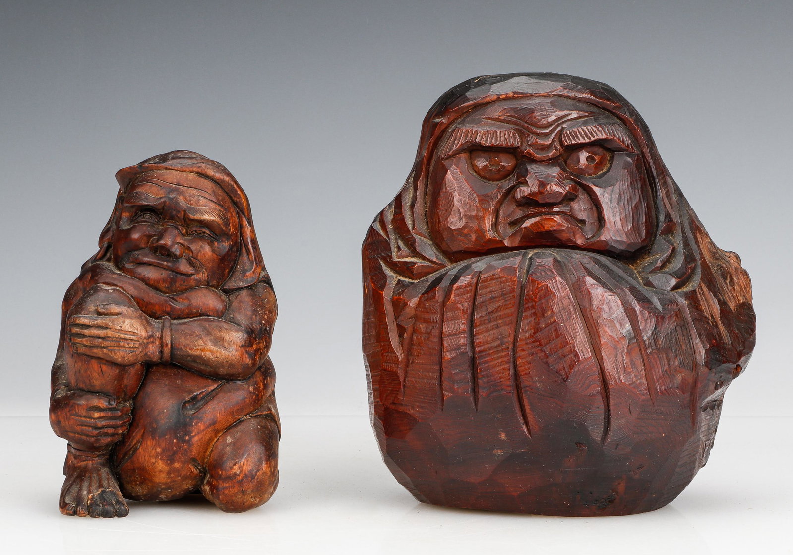 2 Japanese Meiji Carved Wood Figures, Signed: 2 Japanese Meiji Carved Wood Figures, Signed. Daruma, signed: "Itabori" and another figure. Size: 1) 9'' x 8'' x 5'' (23 x 20 x 13 cm); 2) 7'' x 4'' x 3.25'' (18 x 10 x 8 cm). Provenance: Sylvia and P