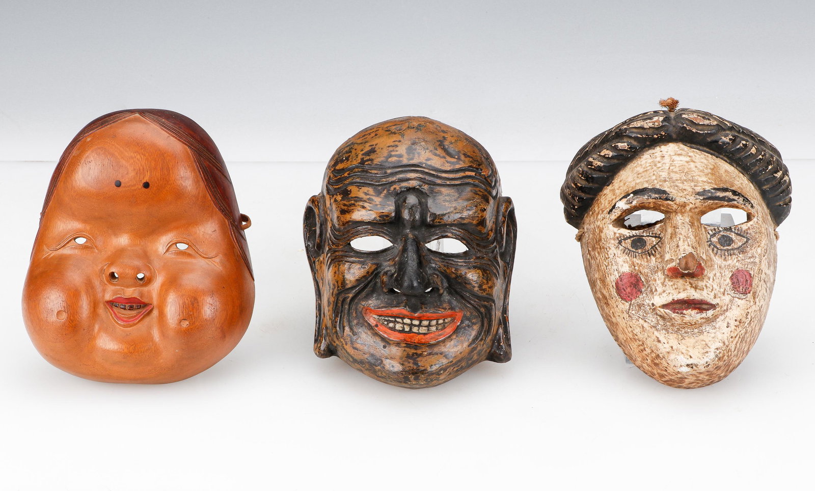 3 Antique Japanese Theater Masks: 3 Antique Japanese Theater Masks. Carved wood, pigment, lacquer. Size: 1) 7'' x 6'' x 2.5'' (18 x 15 x 6 cm); 2) 7.25'' x 4.5'' x 4'' (18 x 11 x 10 cm); 3) 7'' x 5.75'' x 2.25'' (18 x 15 x 6 cm). Prov