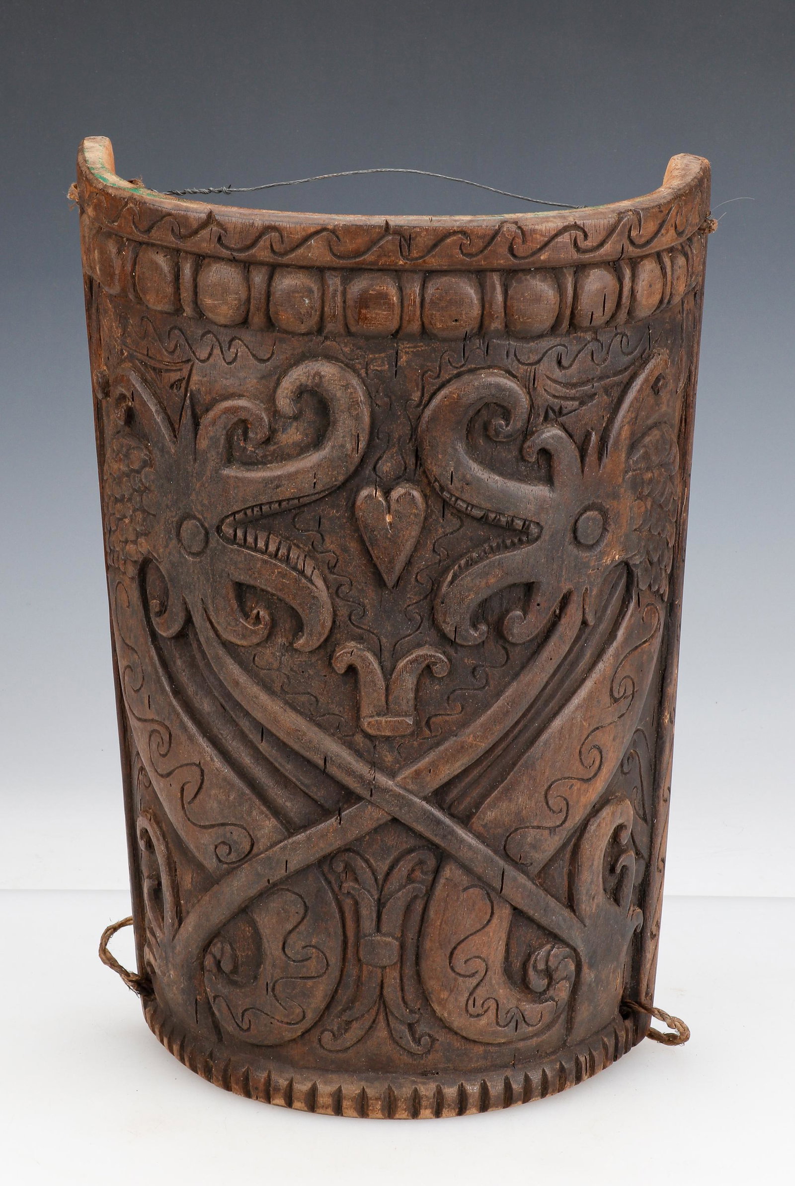 Dayak Carved Wood Baby Carrier, Borneo: Dayak Carved Wood Baby Carrier, Borneo. Depicting a naga (dragon) and other apotropaic symbols designed to ward off evil from the baby and protect the family lineage. Size: 15.5'' x 10.5'' x 5.25'' (3