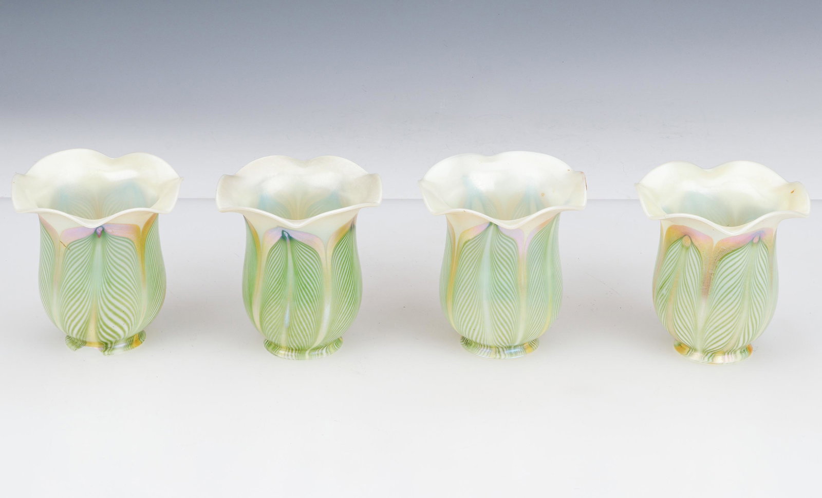 4 Quezal Art Glass Lamp Shades: 4 Quezal Art Glass Lamp Shades. One with chip. Size: Each: 5.25'' x 4.5'' x 4.5'' (13 x 11 x 11 cm). Provenance: Sylvia and Philip Chaplain Collection, New Hampshire.