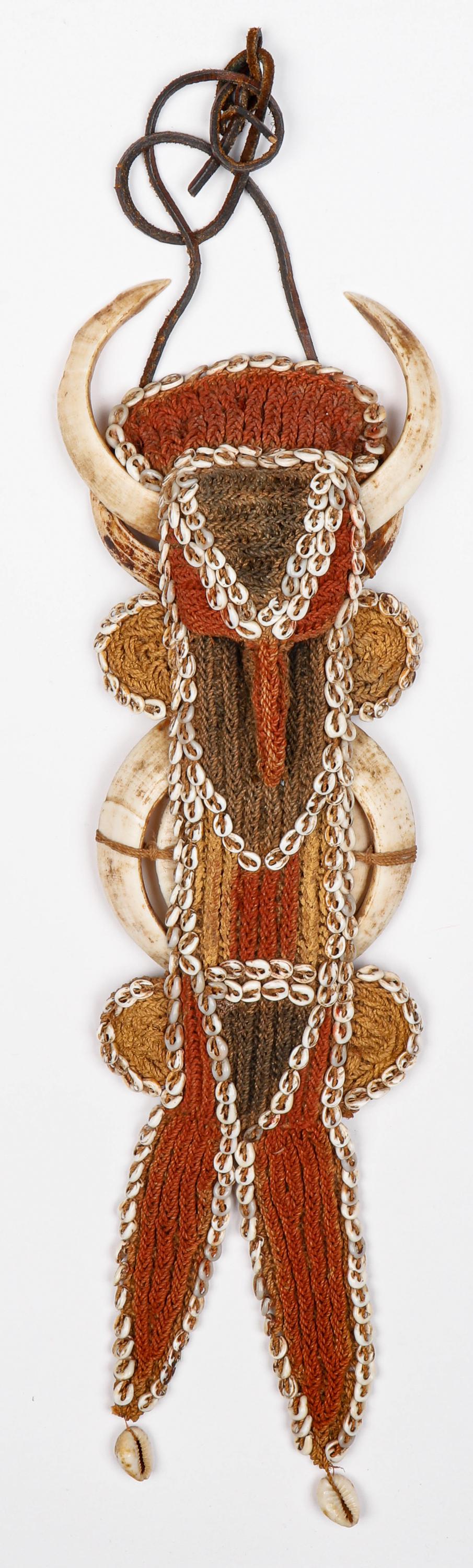 Body Ornament, Karaut, Abelam People, East Sepik, PNG: Body Ornament, Karaut, Abelam People, East Sepik, PNG. Worn on chest or back or held in teeth especially during battle. Three pair of boarâ€™s tusks highlight the woven Nassa shell and pigmented 