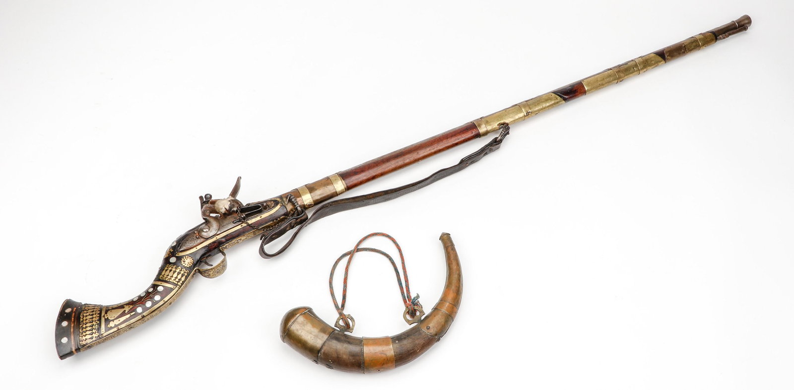 Antique North African Camel Gun, 18th/19th Century: Antique North African Camel Gun, 18th/19th Century. Flintlock with bone inlaid stock. Together with powder horn. Size: 1) 59'' x 6'' x 3'' (150 x 15 x 8 cm); 2) 13'' x 3'' x 3'' (33 x 8 x 8 cm). From 