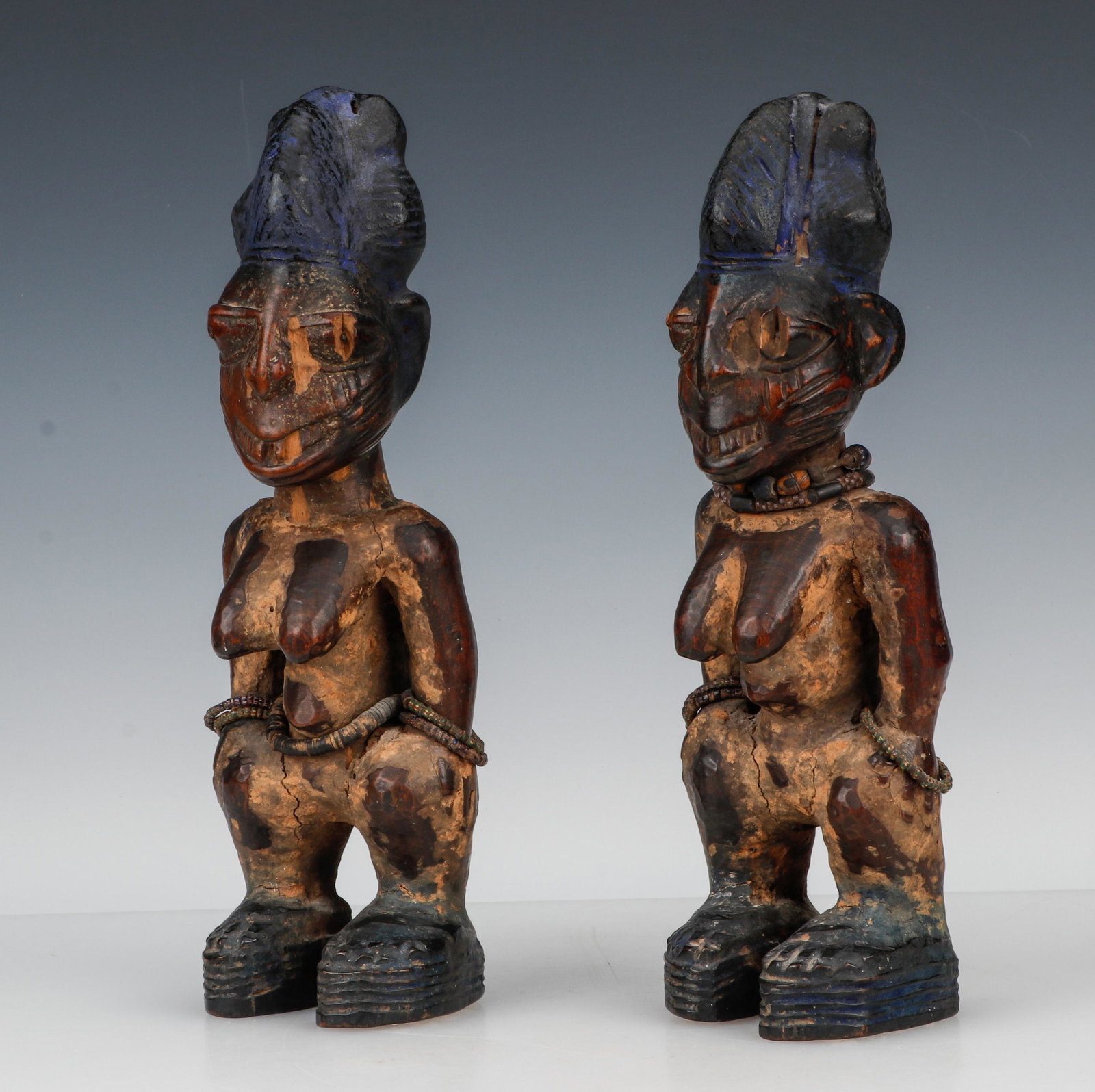 Pair of African Yoruba Female Ibeji Figures, Nigeria: Pair of African Yoruba Female Ibeji Figures, Nigeria. Carved wood, pigment and beads. Property from the collection of Helen Cunningham and Ted Newbold, Philadelphia, PA. Sizes: 1) 12'' x 4'' x 3.5'' (
