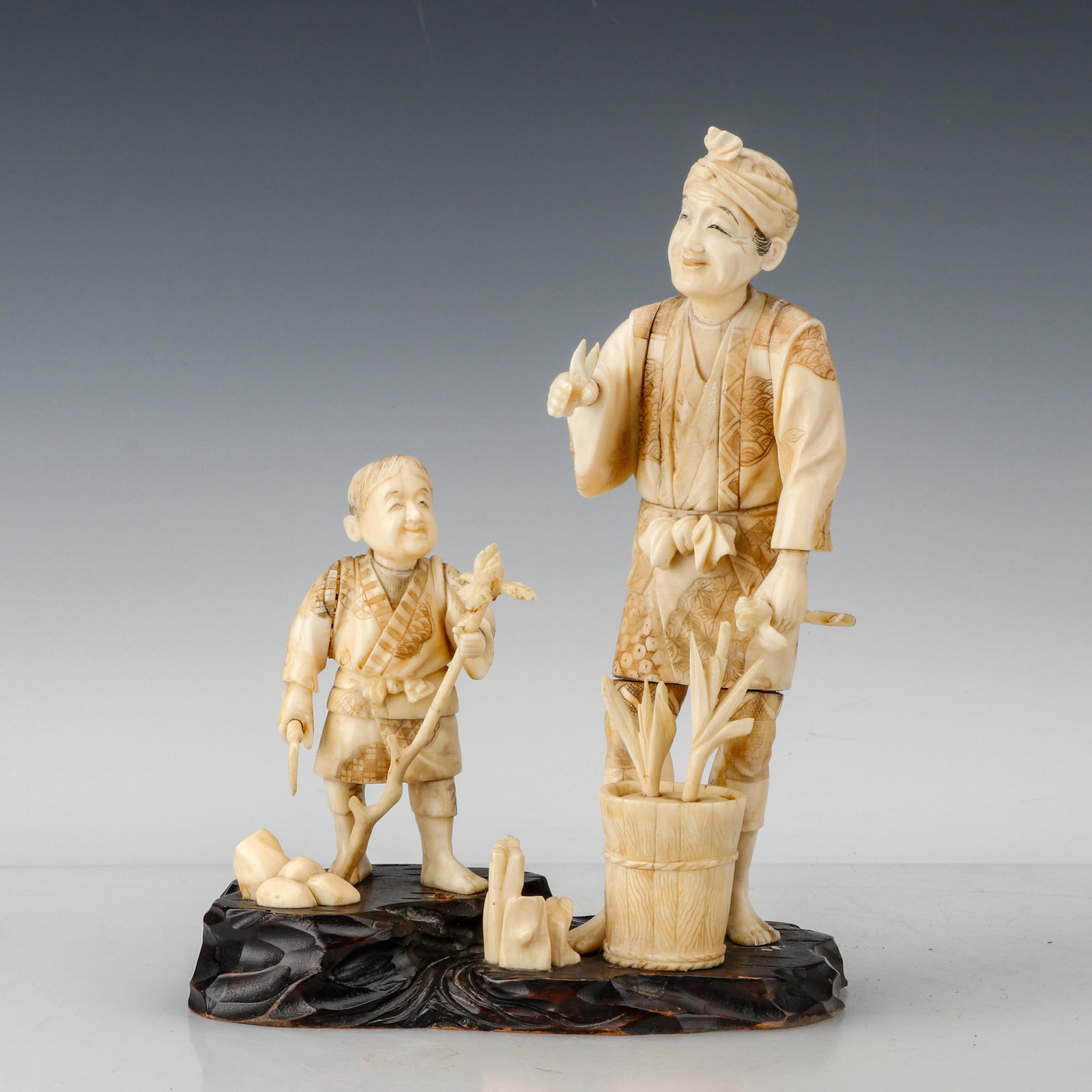 Japanese Okimono of a Flower Seller, Meiji Period: Japanese Okimono of a Flower Seller, Meiji Period. Depicting a smiling man with a sprig of plum in one hand and a pair of scissors in the other, a basket containing more branches at his feet, and his 