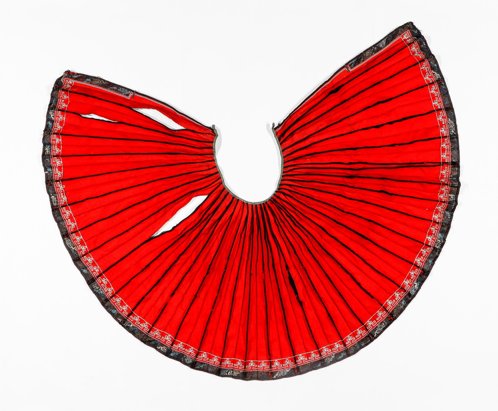 Miao Skirt Textile, 20th Century: Miao Skirt Textile, 20th Century. Open sided skirt of wool twill with narow waistband. Each pleat is cut as a separate piece and sewn; a cotton tabby edging runs vertically from waist to hem on the ou