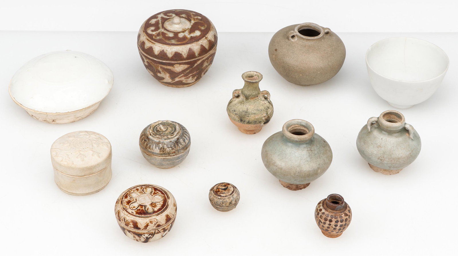 Collector's Lot of Asian Pottery: Collector's Lot of Asian Pottery. Including: 4 Antique Chinese Pottery Vessels. Ranging in Size: 2.75'' x 2.25'' x 2.25'' (7 x 6 x 6 cm) to 3'' x 3.5'' x 3.5'' (8 x 9 x 9 cm). Together with 3 Thai Swa