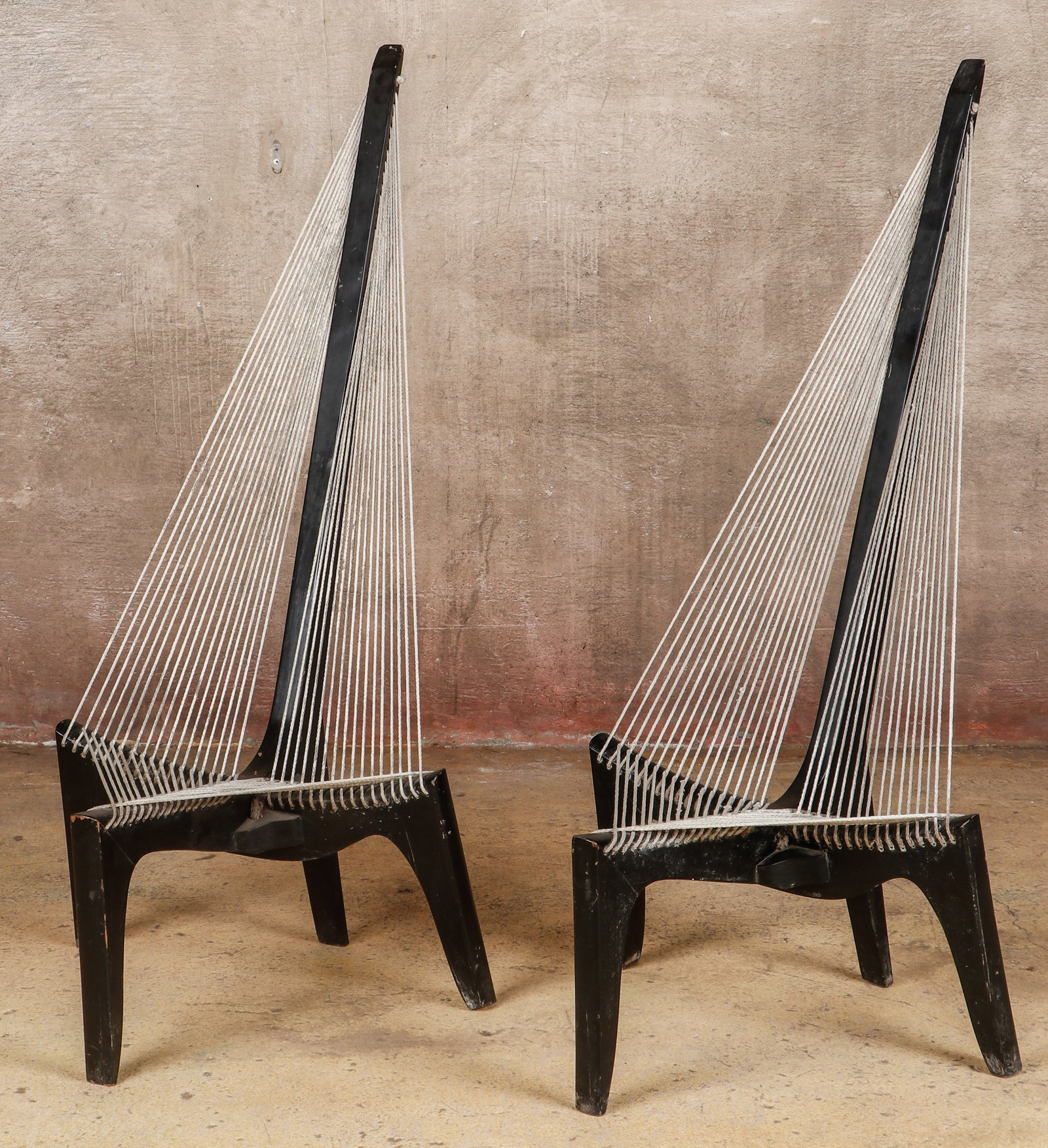 2 Indian Modernist Teak Harp Chairs in the Manner of Jorgen Hovelskov (Danish, 1935-2005): Indian Modernist Teak Harp Chairs in the Manner of Jorgen Hovelskov (Danish, 1935-2005). Sculptural, three leg lounge chair. Flagline rope seat and back. Size: Each 57'' x 29'' x 36'' (145 x 74 x 91 c