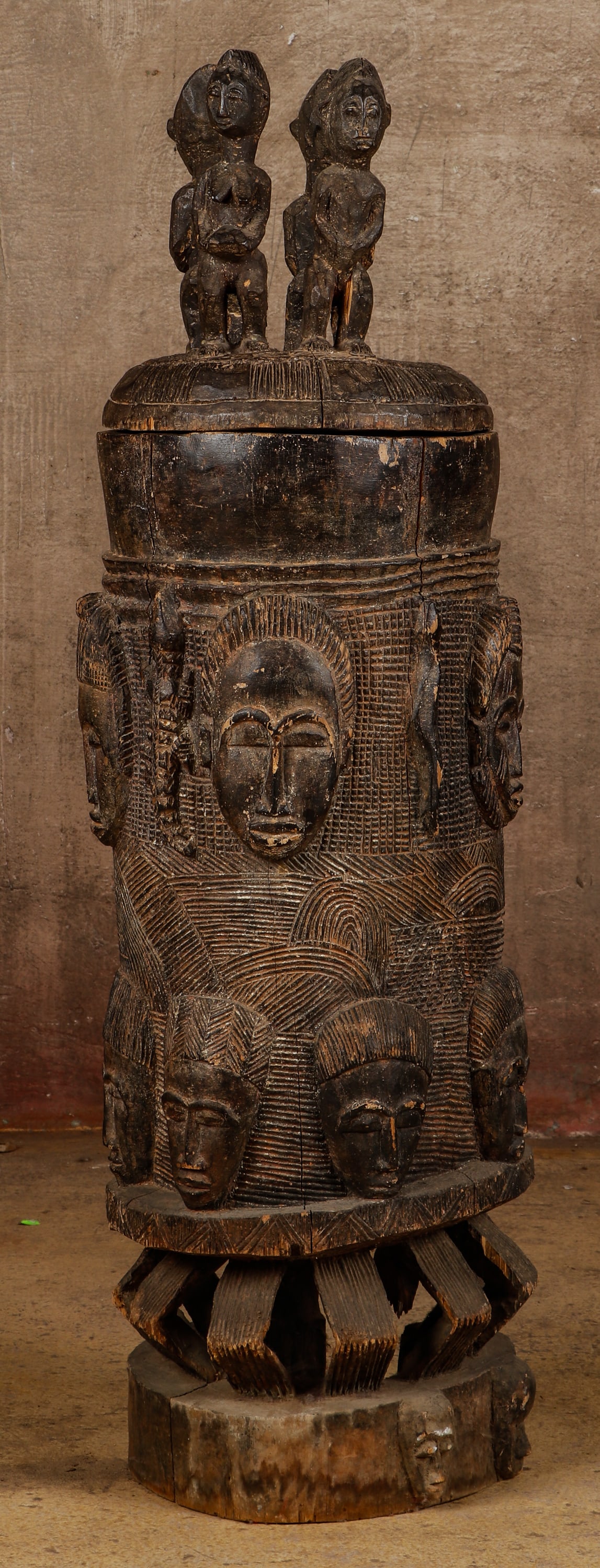 African Yoruba Tall Carved Wood Ceremonial Lidded Vessel, H. 51": African Yoruba Tall Carved Wood Ceremonial Lidded Vessel with geometric, figural and face carvings. Size: 51'' x 15'' x 15'' (130 x 38 x 38 cm).