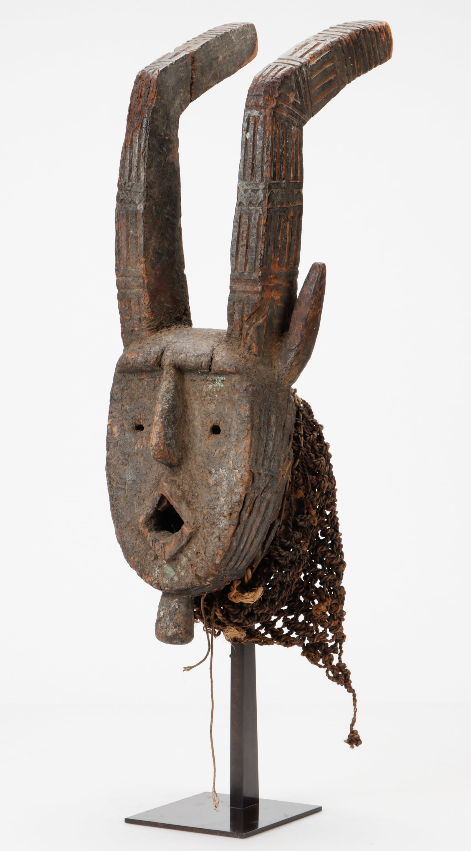 Winiama Two-Horned Mask, Burkina Faso, L: 25": Winiama Two-Horned Mask, Burkina Faso. On stand. Wood, natural pigments. Size: 25'' x 7'' x 10'' (64 x 18 x 25 cm). Height on stand: 31" (79 cm). This is one of the older masks in a collection full of