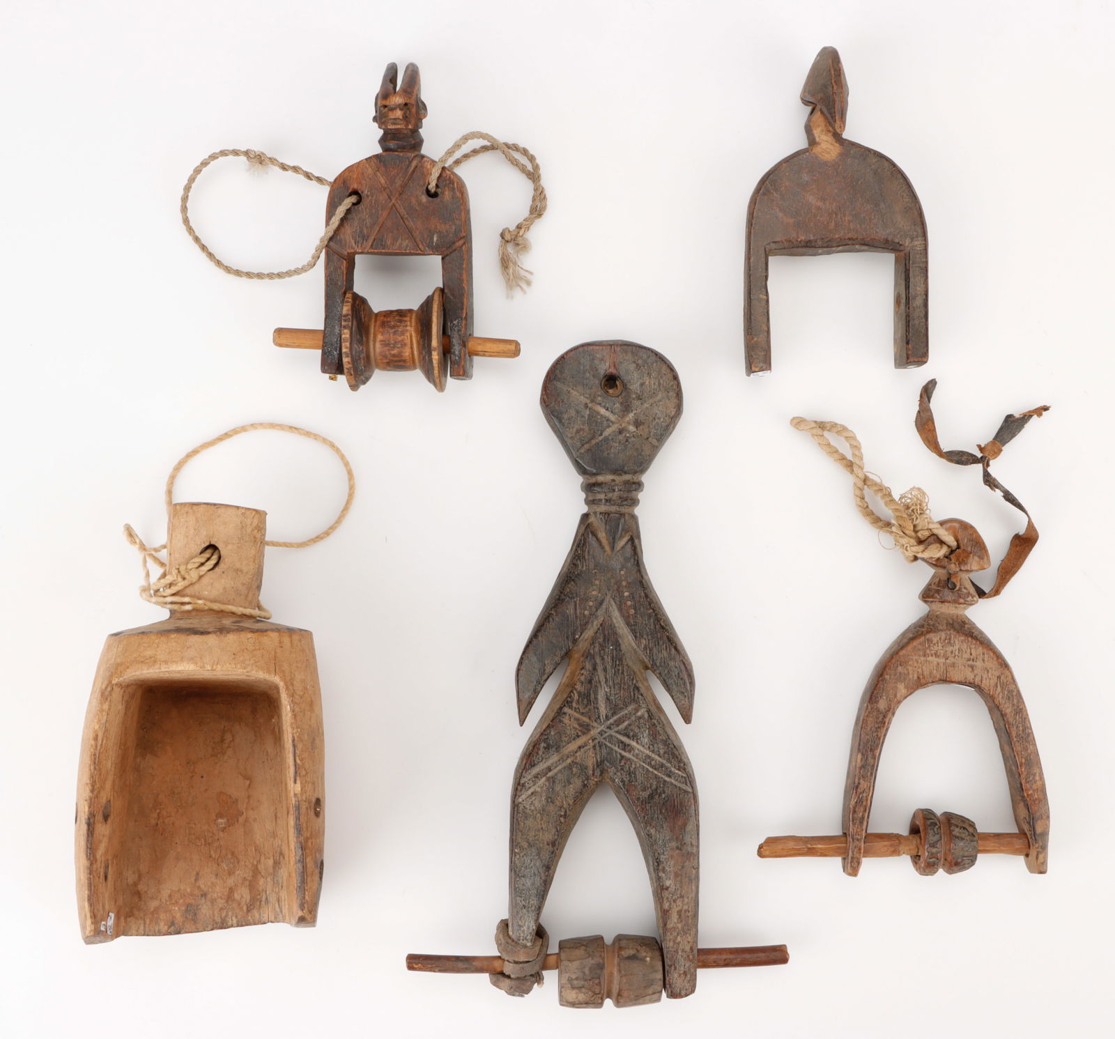 Group of 5 West African Heddle Pulleys, Thomas G. B. Wheelock Collection: Group of 5 West African Heddle Pulleys, Burkina Faso. Wood, leather, fiber, cord. Sizes Ranging From: 5" (13 cm); To: 11" (28 cm). Provenance: Thomas G. B. Wheelock Collection, New York.