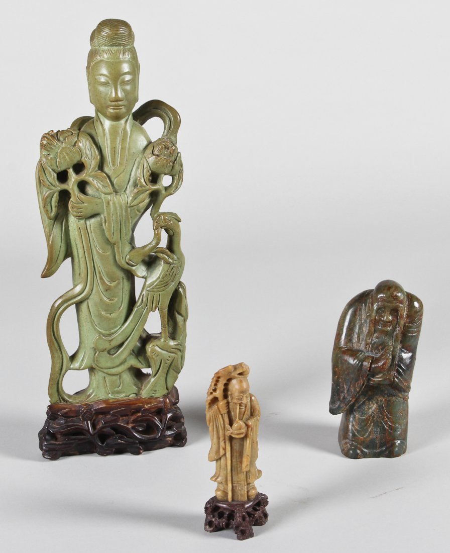 Three Chinese Hard Stone Carvings: Three Chinese Hard Stone Carvings: Tall Quan Yin. (16 x 6 x 3 inches). Soapstone Luhan Figure on Stand (6 x 2.25 x 1.5 inches). Green Stone Luhan Figure (6.5 x 3.5 x 2.5 inches).