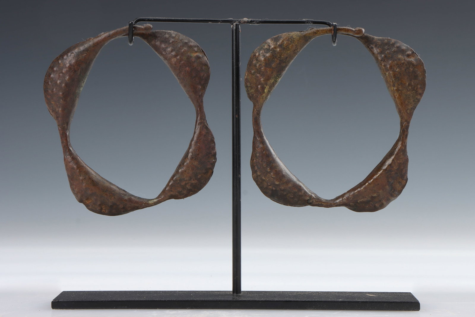 2 Antique Chamba African Metal Currency Ankle Rattles, Nigeria: 2 Antique Chamba African Metal Currency Ankle Rattles, Nigeria. On one stand. Sizes: 1) 5'' x 5'' (13 x 13 cm); 2) 5'' x 4.5'' (13 x 11 cm); Height on Stand: 8" (20 cm).
