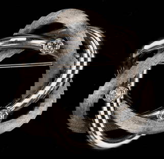 .750 White Gold And Diamond Brooch: .750 White Gold And Diamond Brooch. 3 diamonds. Marked: .750. Diameter: 1" (3 cm). Gemstones have not been weighed, or graded for color and clarity. 4.2 pennyweight.