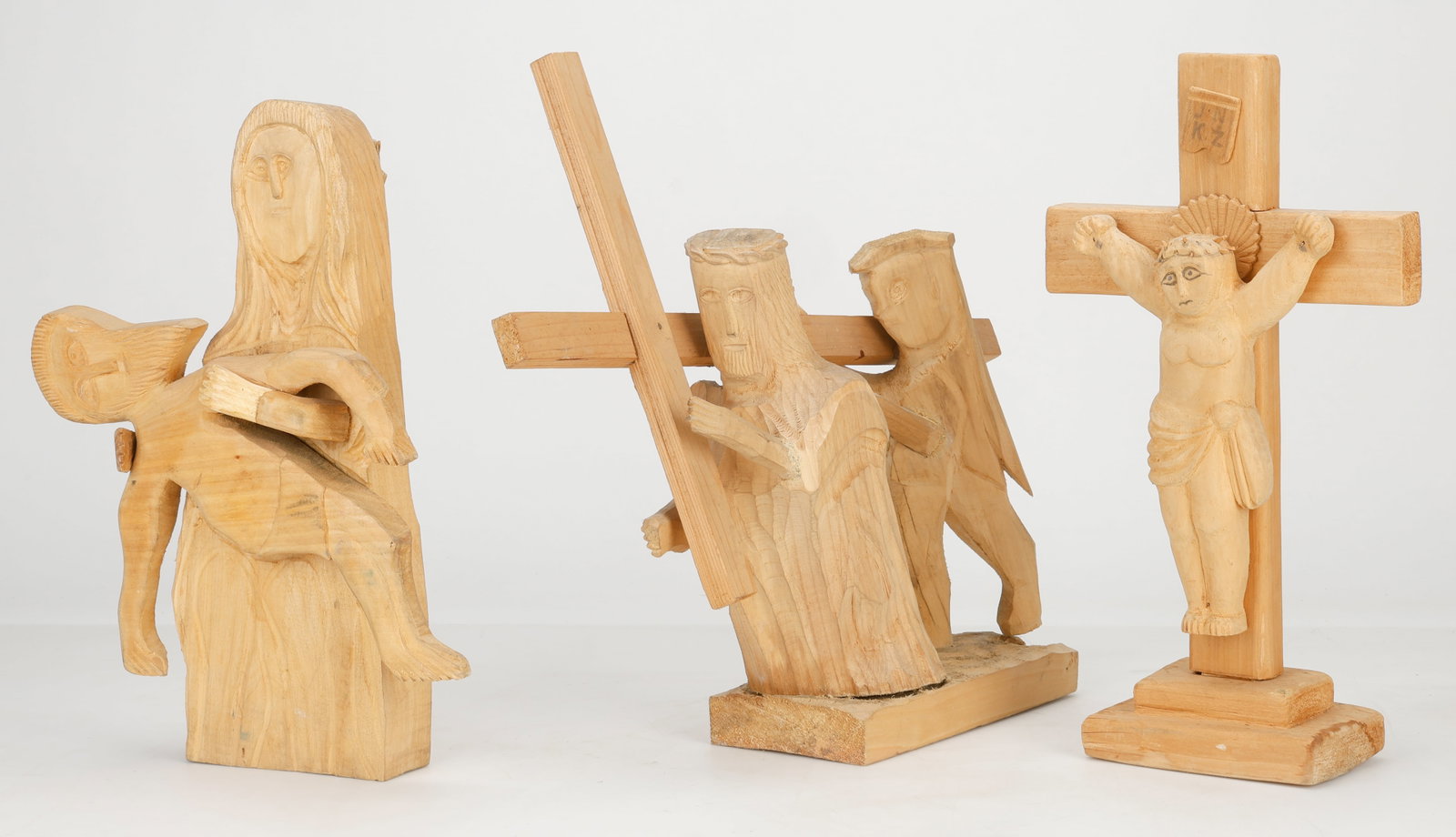 3 Polish Folk Art Wood Carvings of Christ Stations of the Cross: 3 Polish Folk Art Wood Carvings Depicting various Stations of the Cross. Including 2 by Jan Maida. Pieta and Christ Carrying the Cross, each signed and dated 1991. Together the Crucifixion of Jesus. H