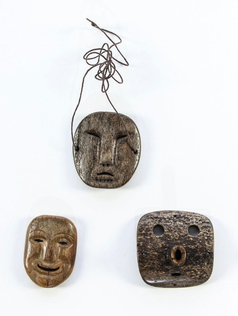 Three Northwest Coast Fossilized Walrus Ivory and Whale: Lot of 3 Northwest Coast talismans. One carved of walrus ivory measuring 2.25" x 1.625" x .375" and two carved of whale bone the larger measuring 2.375" x 2.375". Provenance: Max Garb, Chicago, Illino