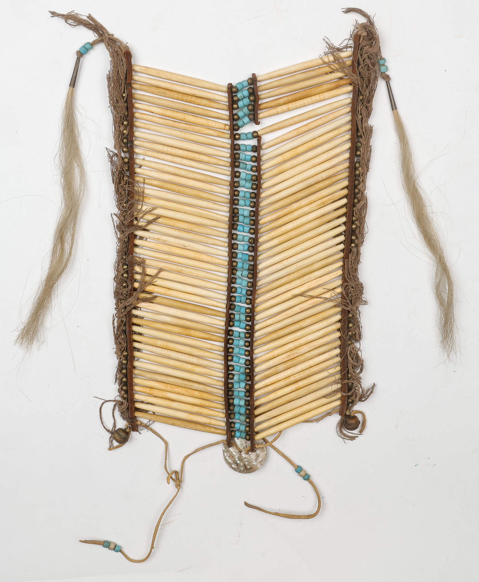 Native American Plains Indian Breastplate: Native American Plains Indian Breastplate. Bone tube beads, turquoise beads, metal, hide, horse hair. 20th C. Size: center: 16'' x 10'' (41 x 25 cm).