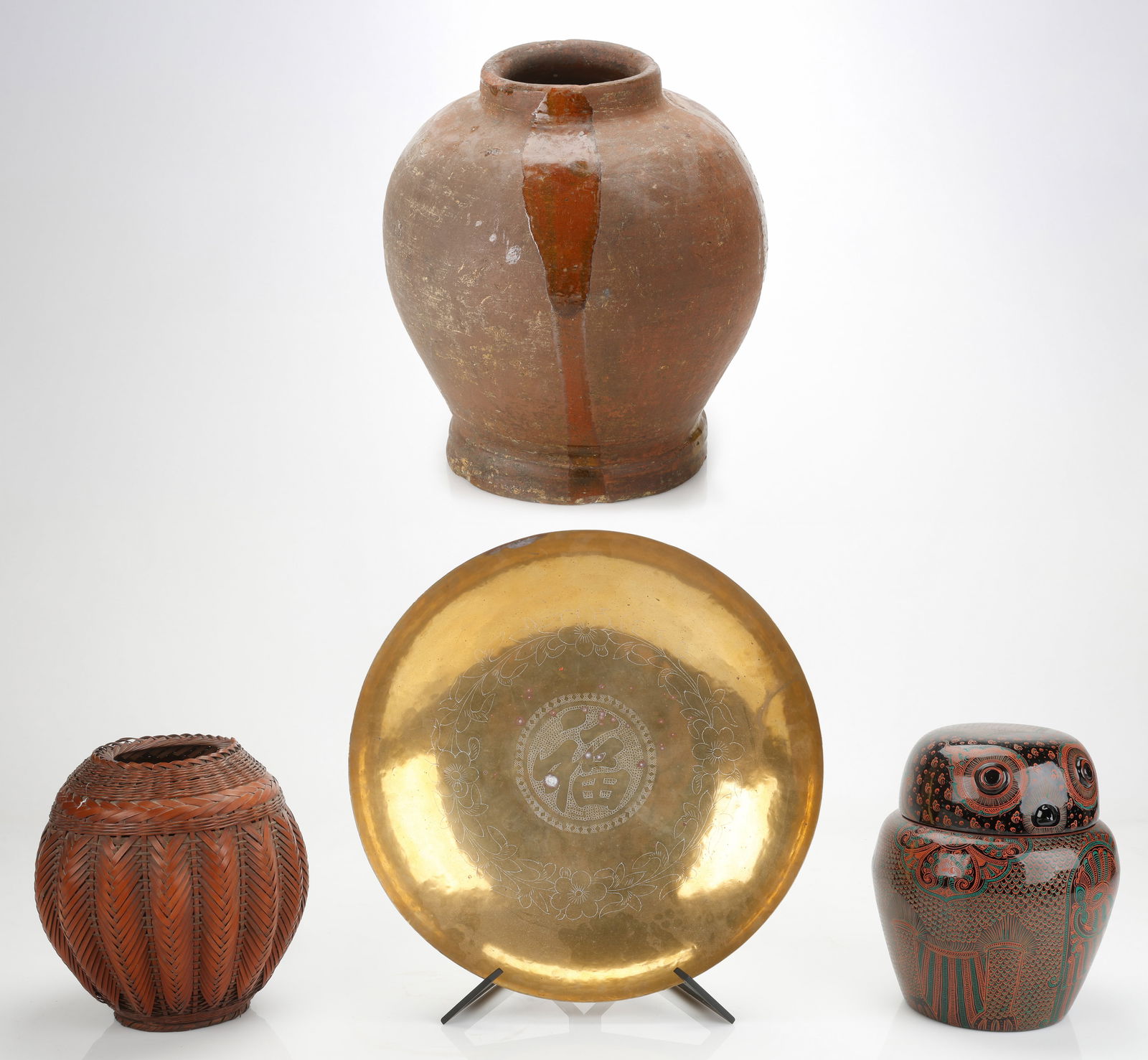 Ethnographic Collector's Lot: Ethnographic Collector's Lot. Large Clay pot. Size: 15.5'' x 13'' x 13'' (39 x 33 x 33 cm). Together with a basket, brass charger on stand, lacquer owl-form covered bowl. Sizes From: 11'' x 9'' x 9''