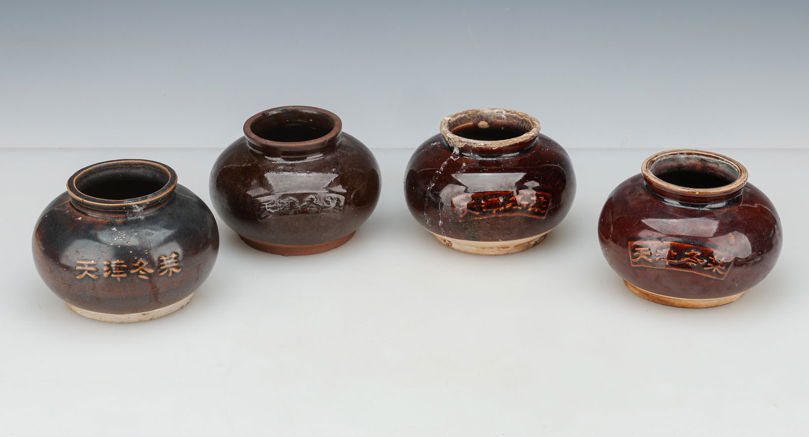 4 Chinese Brown Glazed Pottery Ginger Jars: 4 Chinese Brown Glazed Pottery Ginger Jars. Mold-made ceramic vessels, all three with the same inscription. Each Size: 3.5'' x 5'' x 5'' (9 x 13 x 13 cm). Provenance: Private Philadelphia Estate Colle