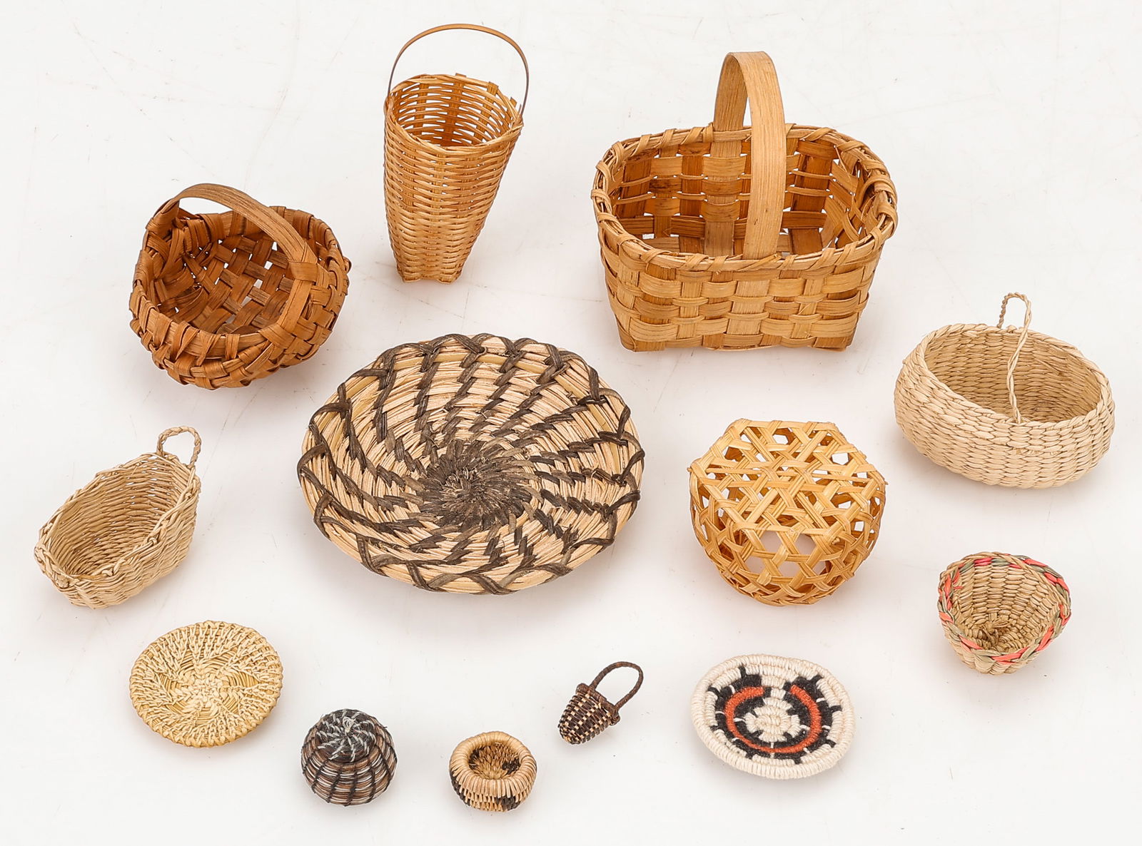 Group of 13 Miniature Native American Baskets: Group of 13 Miniature Native American Baskets. Sizes From: 1'' x .25'' x 25'' (3 x 1 x 64 cm); To: 3'' x 2'' x 2'' (8 x 5 x 5 cm).