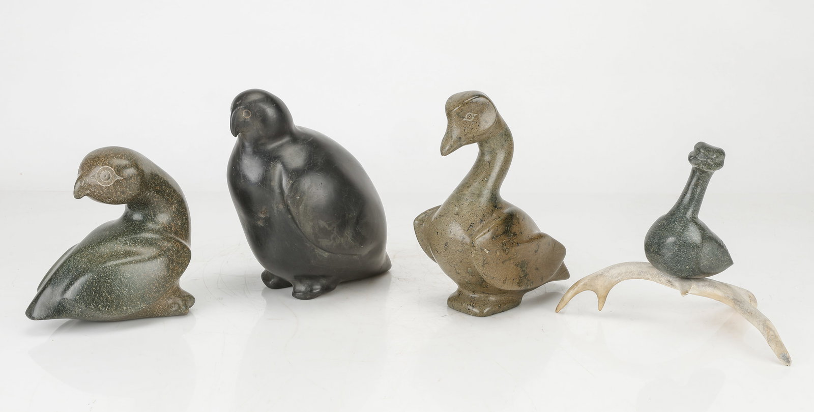 4 Inuit Stone Bird Sculptures, Carved Stone And Bone: 4 Inuit Stone Bird Sculptures. Carved stone and bone. Sizes From: 7'' x 6.5'' x 8.5'' (18 x 17 x 22 cm); To: 8.5'' x 5.5'' x 5.5'' (22 x 14 x 14 cm).