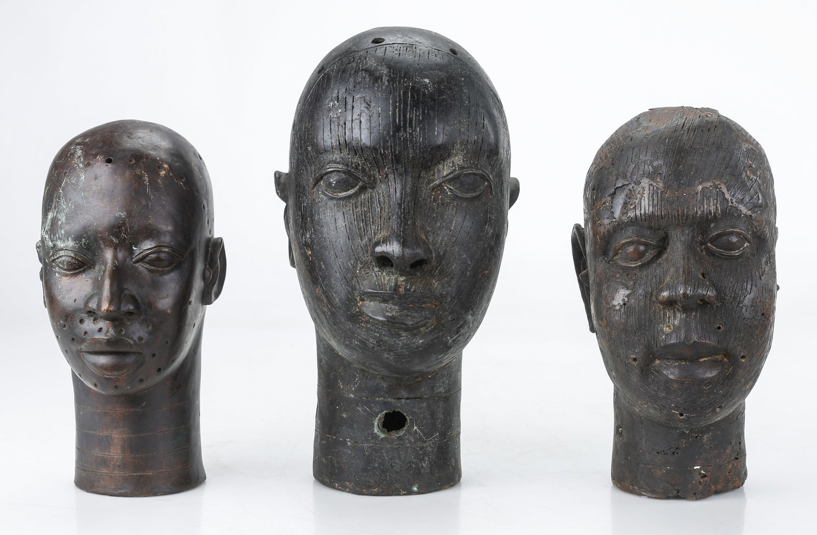 Group Of 3 Benin Bronze Heads, Africa, H: 13"-16": Group Of 3 Benin Bronze Ife Heads, Africa. Sizes From: 13'' x 6'' x 7'' (33 x 15 x 18 cm); To: 16'' x 7'' x 9'' (41 x 18 x 23 cm). Total weight: 30.5 lbs. Provenance: Collection of Charles L. Blockson