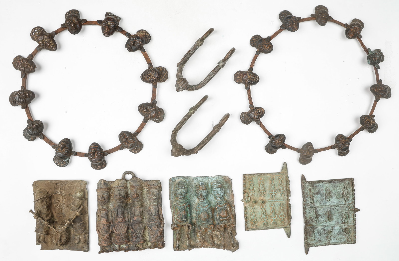 African Collector's Lot Of 9 Bronze Objects, 8" -17": African Collector's Lot Of 9 Bronze Objects. Including 2 Bamun Prestige collars, 3 Benin Warrior Plaques, 2 Dogon Miniature Doors, and 2 possible spurs. Sizes From: 8'' x 5'' x 1'' (20 x 13 x 3 cm); T