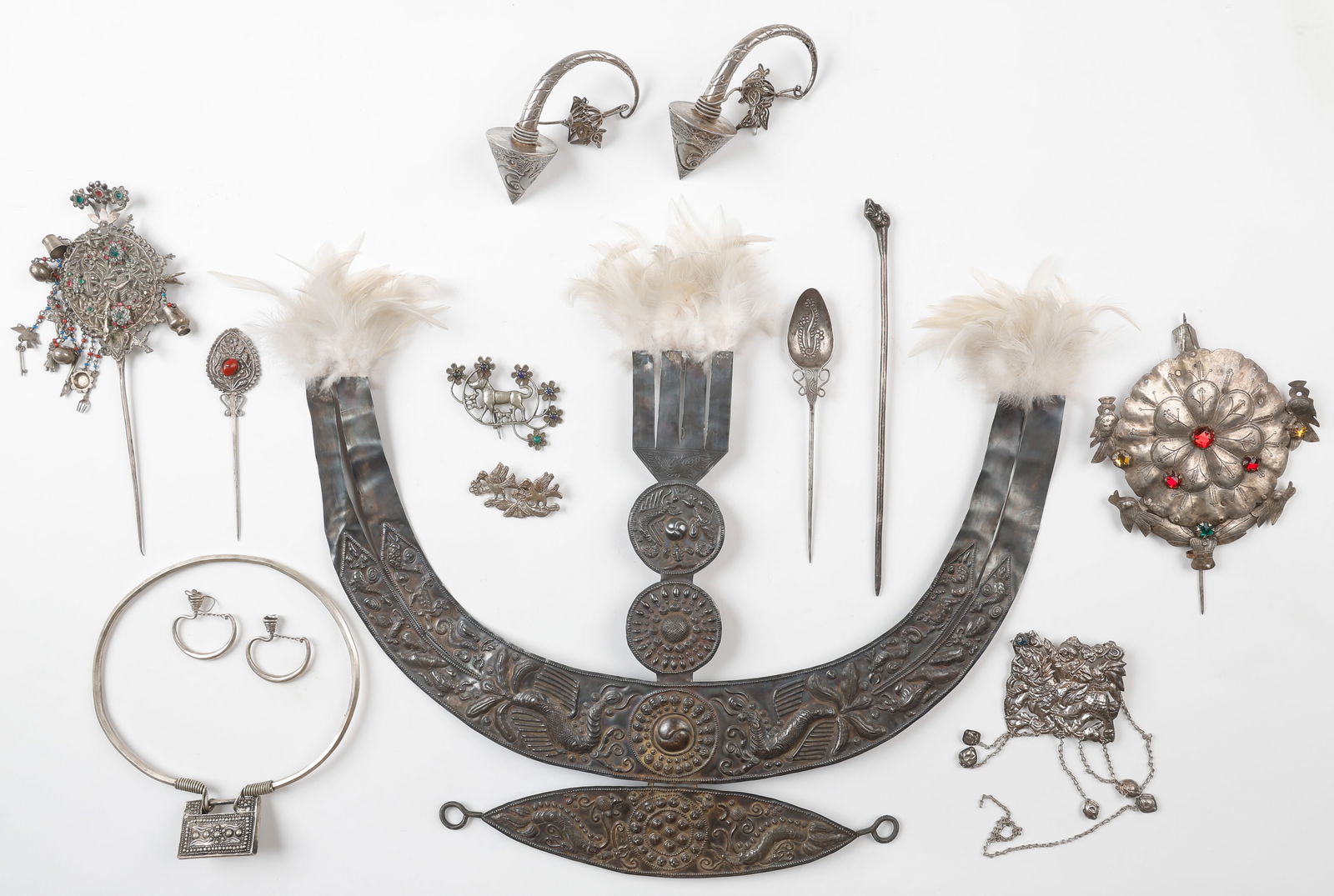 Collector's Lot of 12 Antique Miao Silver Adornments: Collector's Lot of 12 Antique Miao Silver Adornments. Including a Festival Headdress With Feathers, Hair Pins, Brooches, and Earrings. Sizes From: 1.25'' x 2.75'' (3 x 7 cm); To: 15.5'' x 22.5'', 39 x