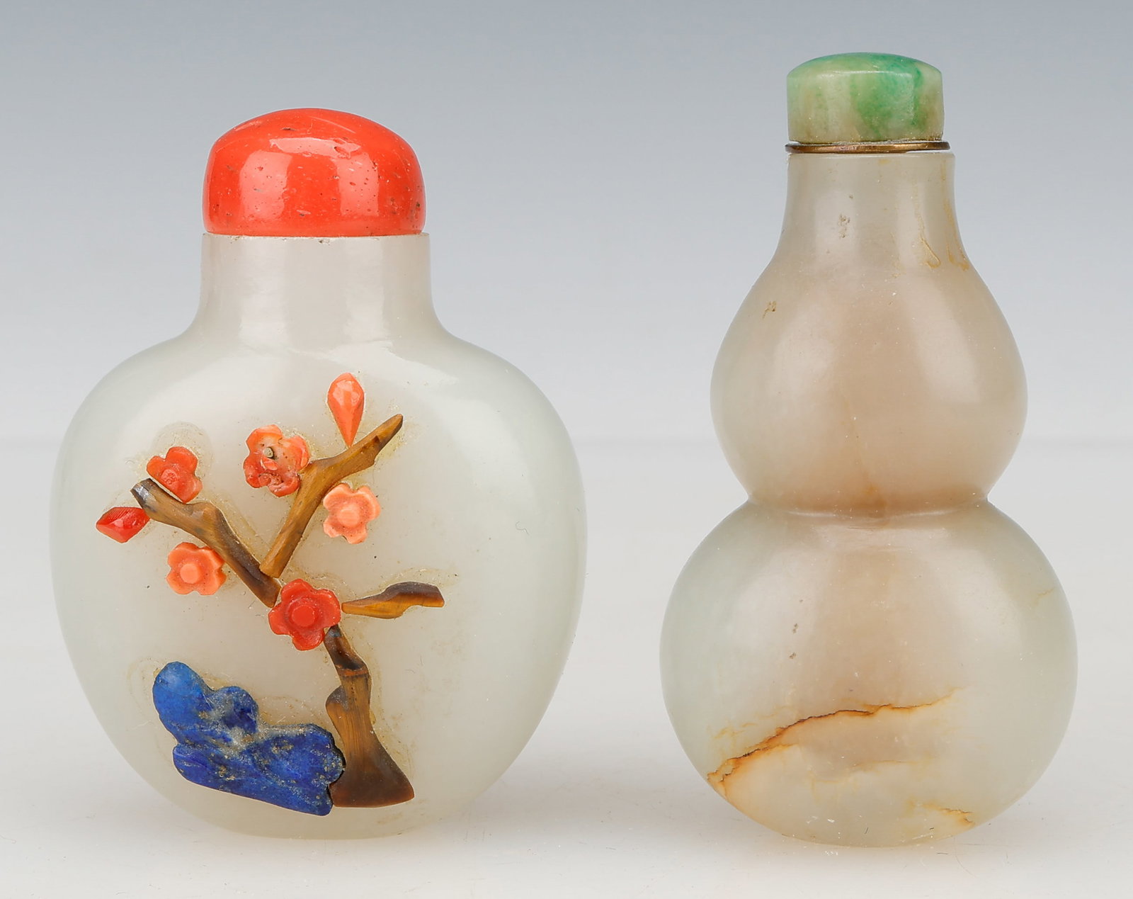 2 Chinese Jade Snuff Bottles, 19th Century: 2 Chinese Snuff Bottles. Including: 1) Chinese jade overlay snuff bottle, circa 1900. 2) Chinese mottled white nephrite double-gourd-form snuff bottle with green stone stopper, 19th C. Sizes: 1) 2.5''