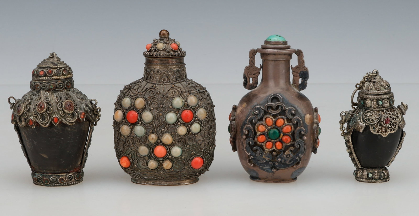4 Chinese And Tibetan-Influenced Snuff Bottles, Late Qing Dynasty through Republic Period, Circa: 4 Chinese And Tibetan-Influenced Snuff Bottles, Late Qing Dynasty through Republic Period, Circa 1880-1930. Including silvered filigree-mounted examples inset with coral, turquoise, and pale hardstone